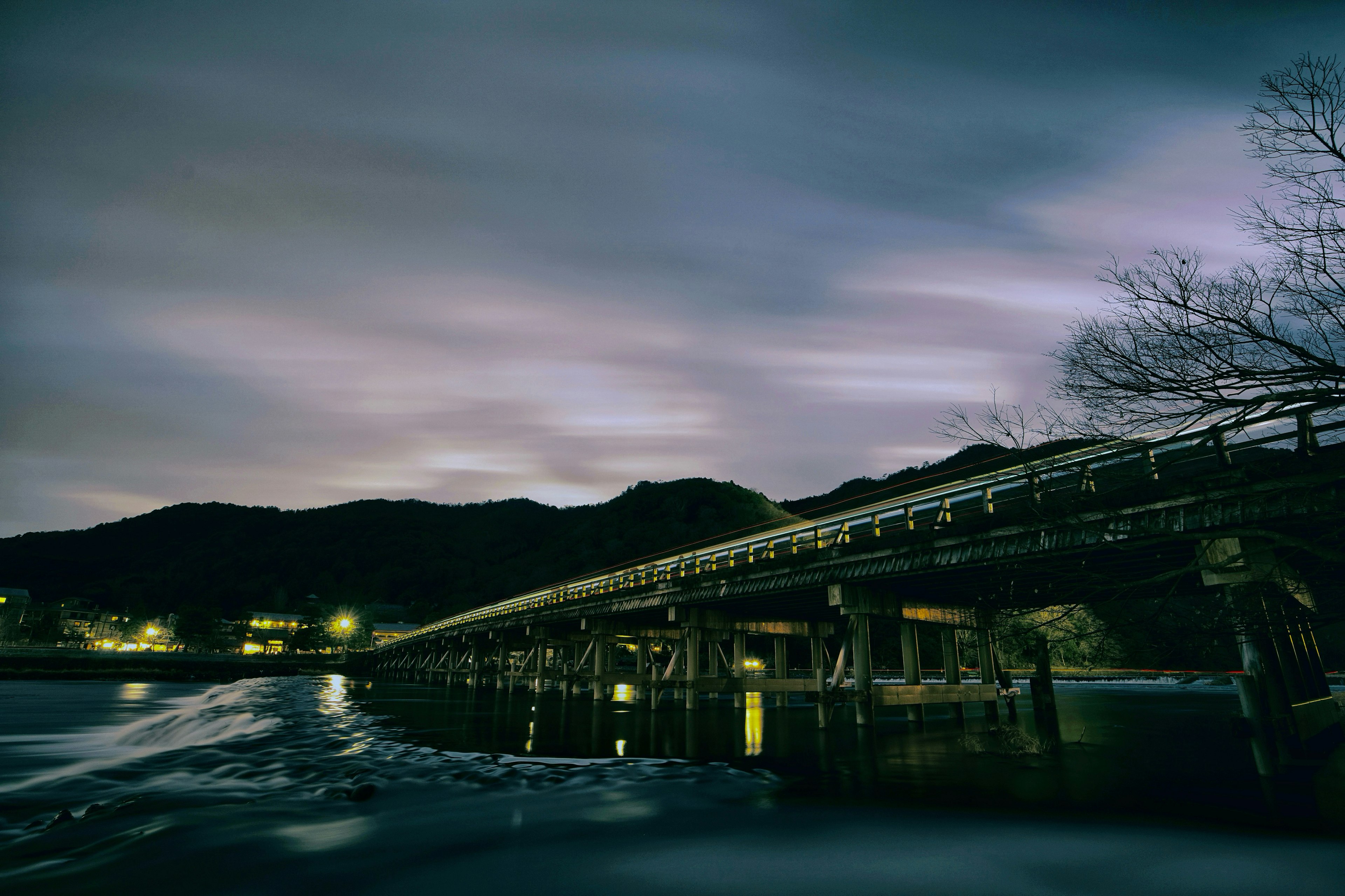 Pemandangan malam jembatan dan gunung dengan struktur kayu panjang