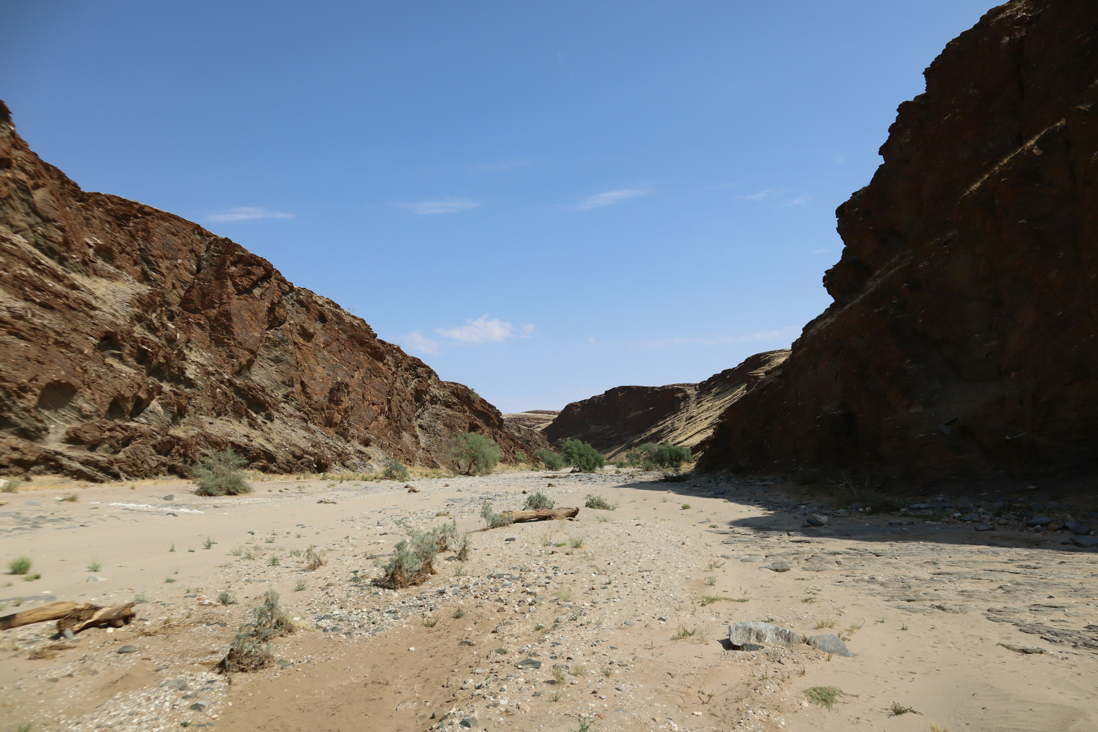 Dry riverbed in a canyon with blue sky