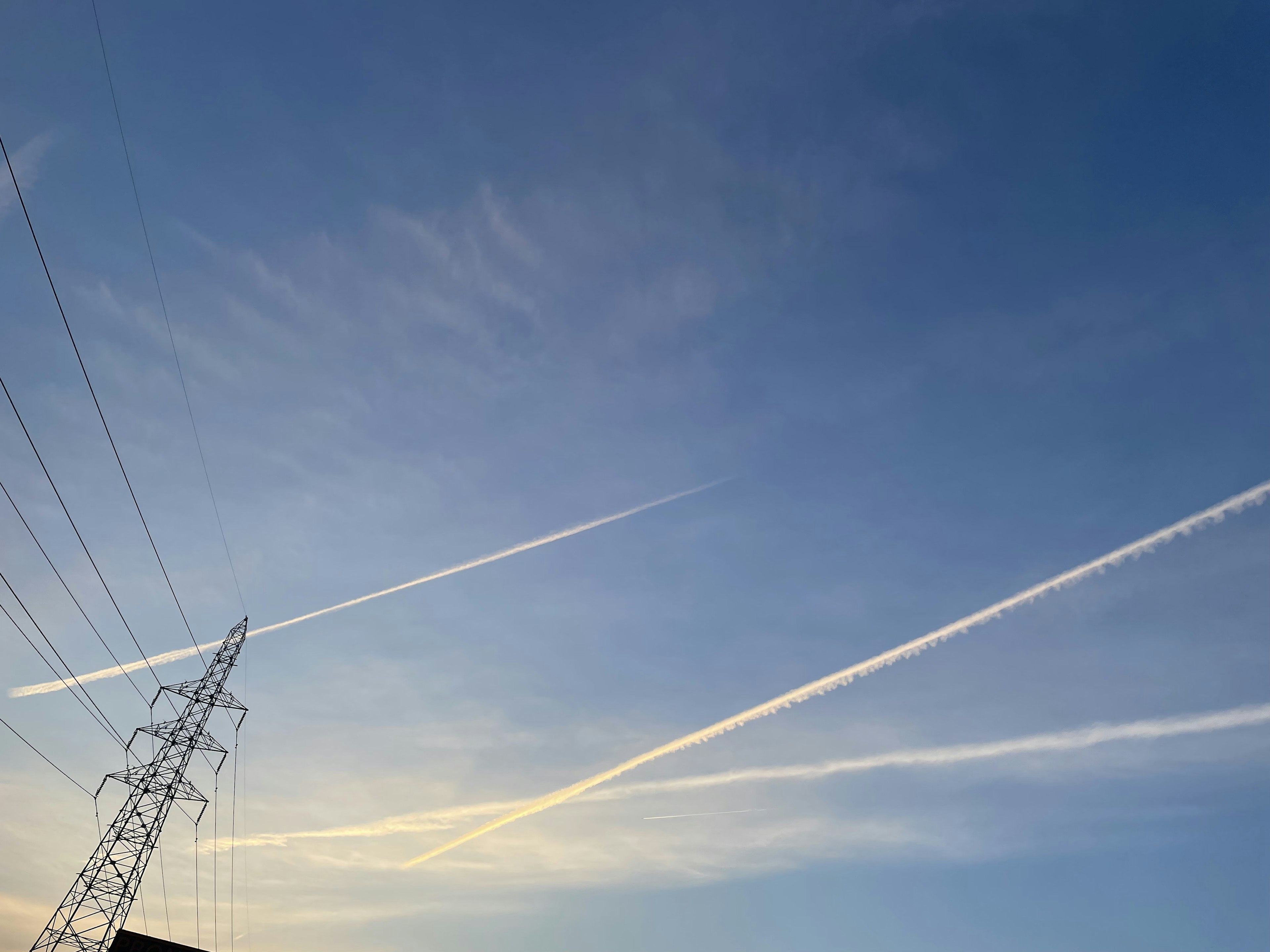 青空に広がる飛行機雲と電柱