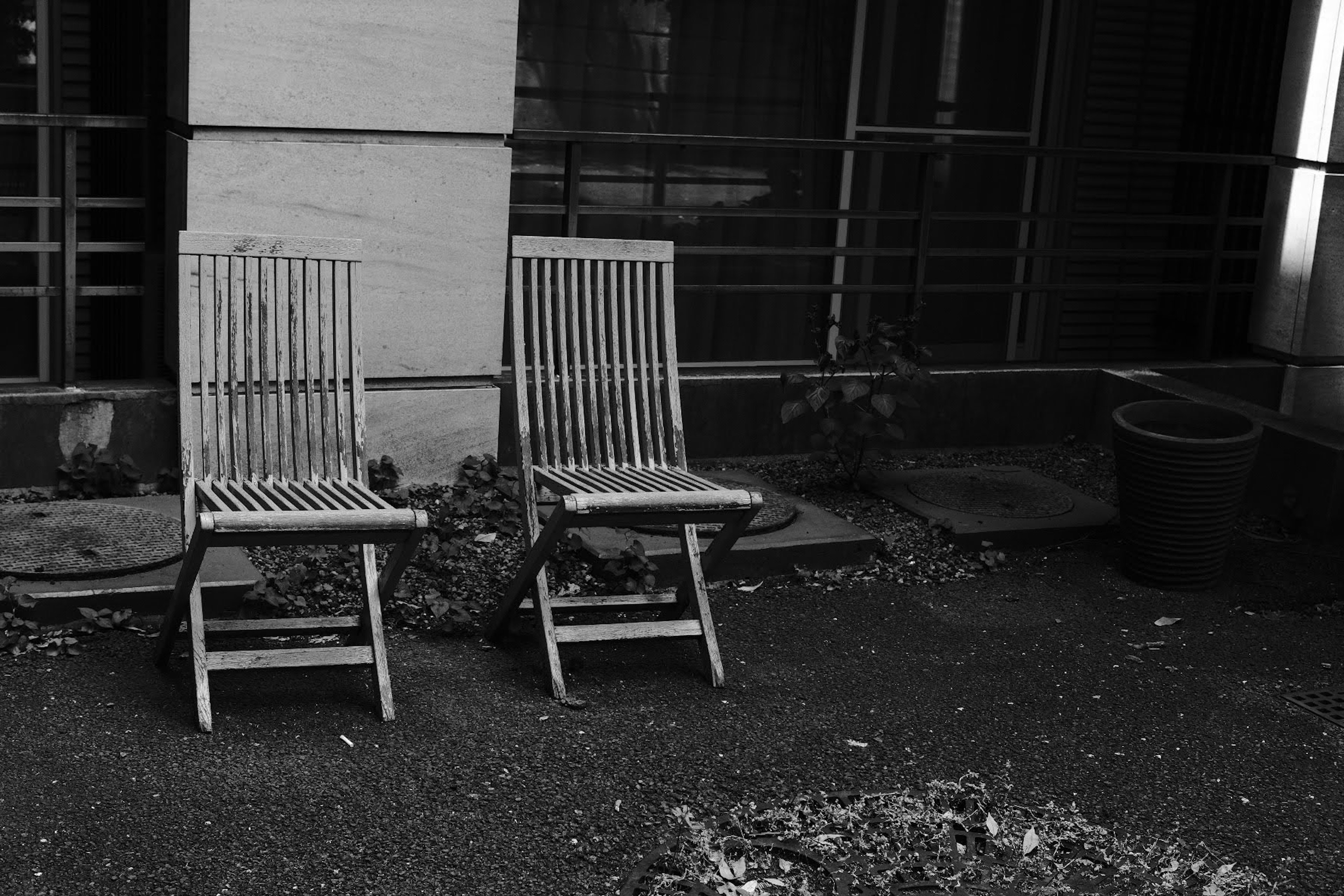 Two wooden chairs placed side by side in a garden area