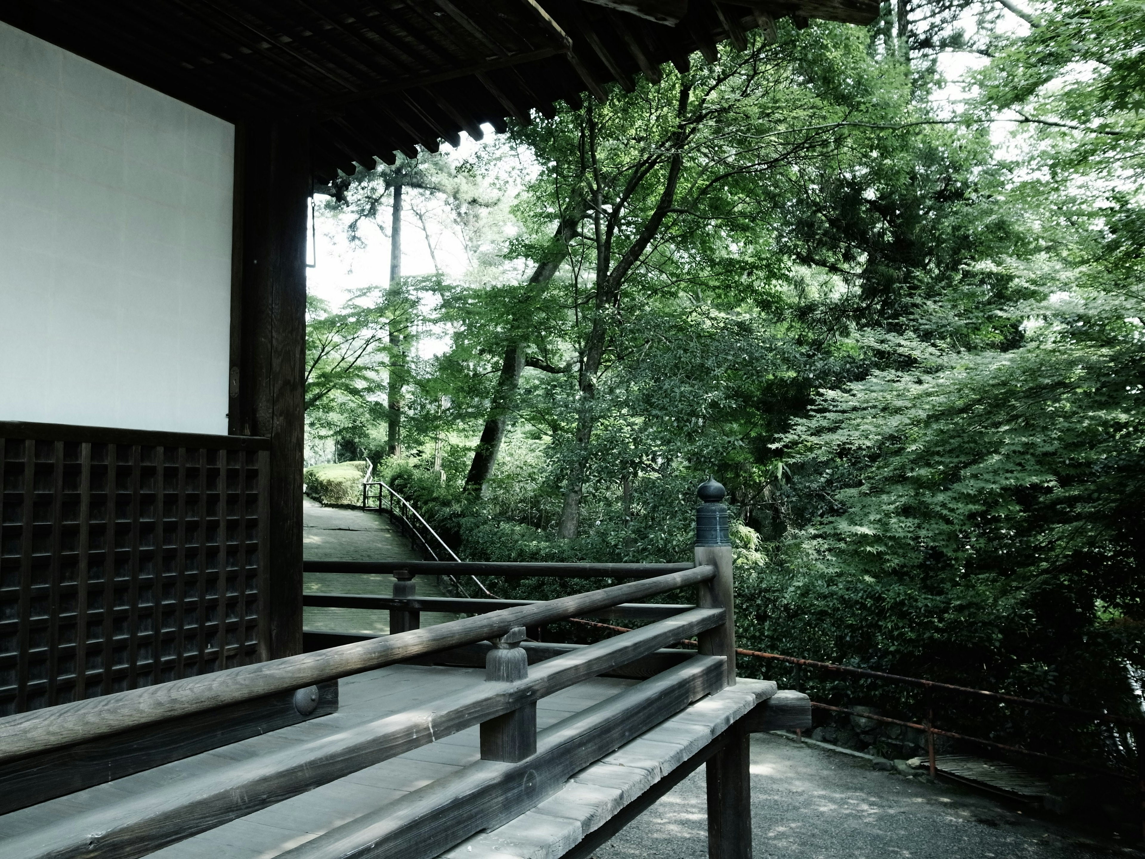 Terrasse d'un bâtiment japonais traditionnel avec un arrière-plan verdoyant