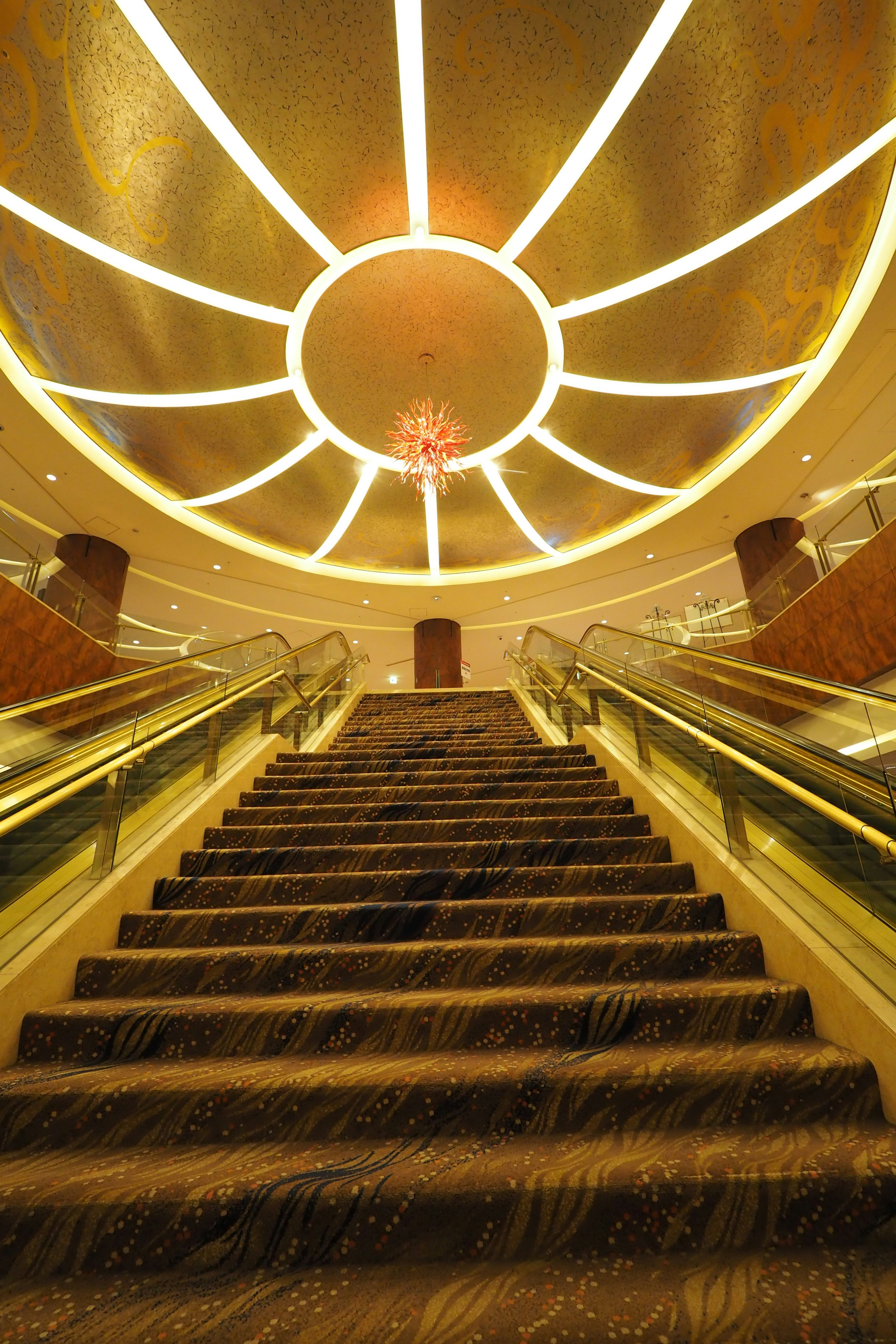 Elegant staircase leading up to a beautifully designed ceiling with lighting