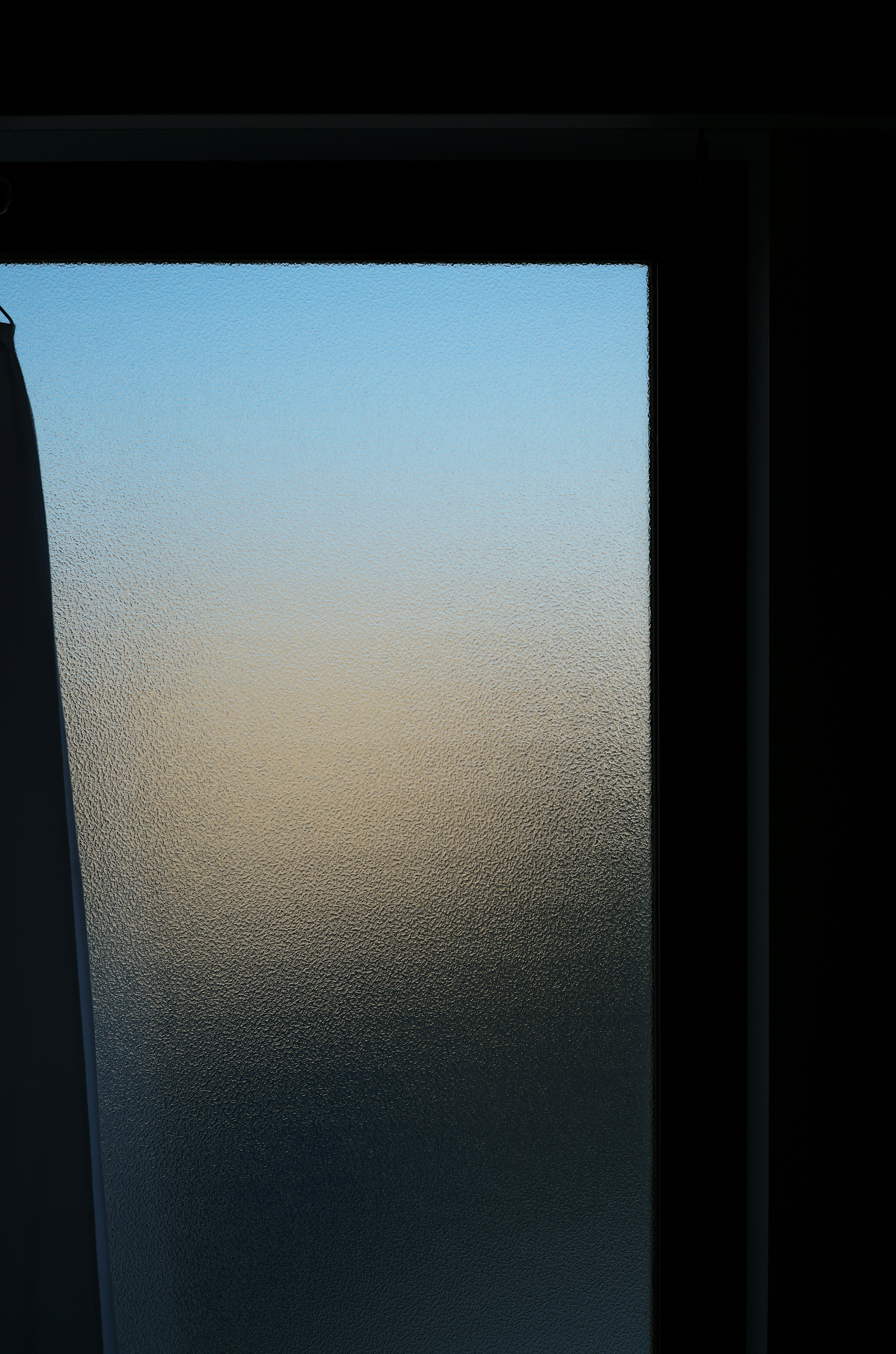 Frosted glass window featuring a gradient of blue sky and blurred landscape