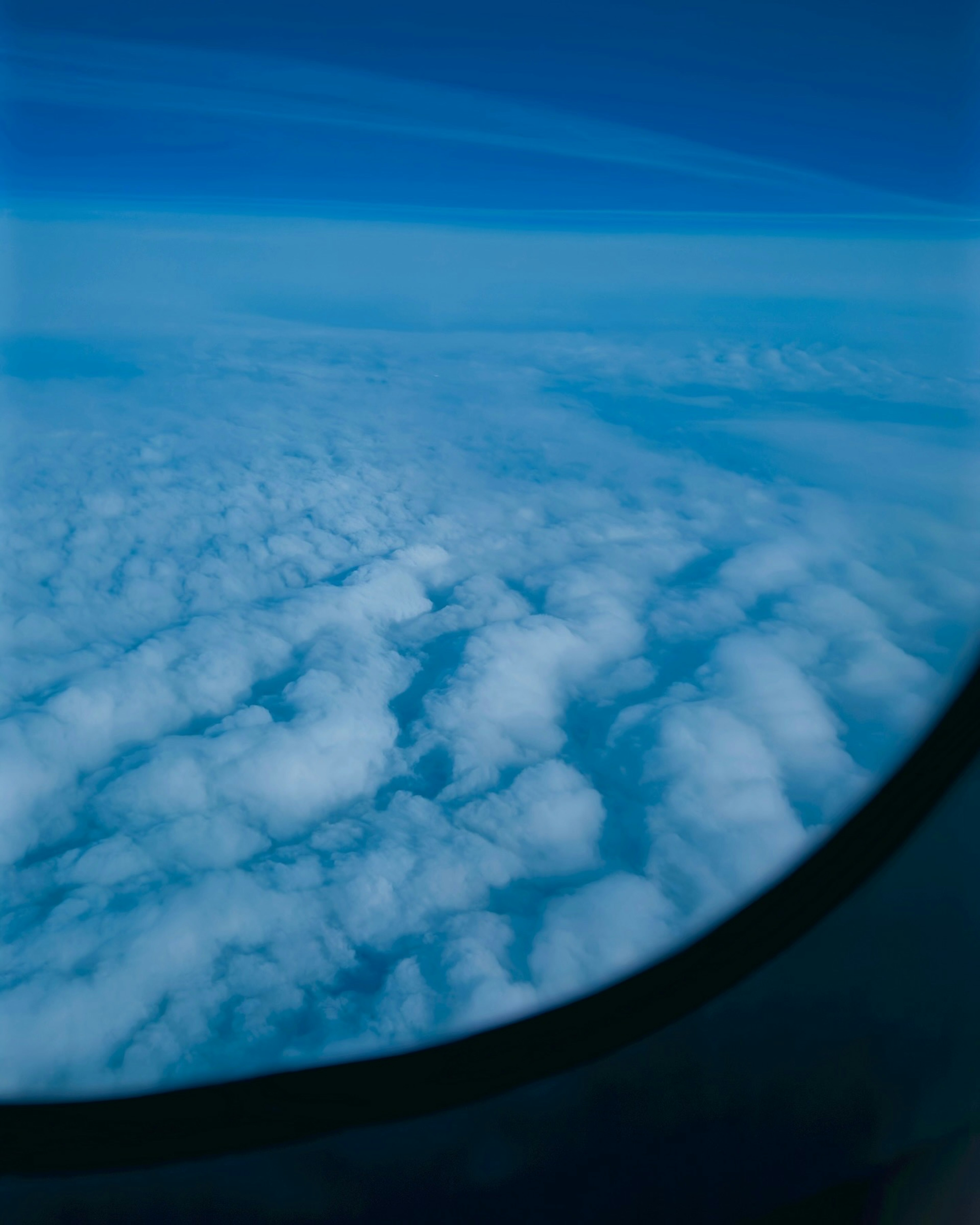 青い空と白い雲の美しい景色が見える飛行機の窓からの眺め