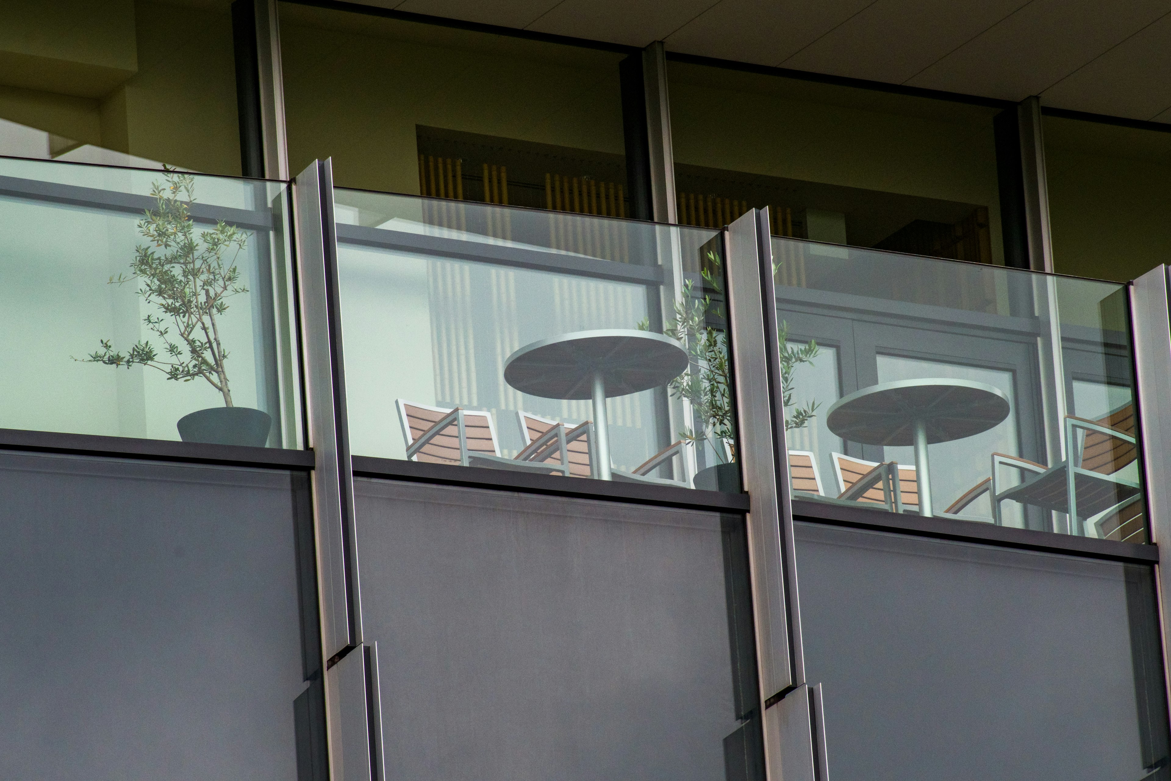 View of a glass balcony featuring tables and chairs