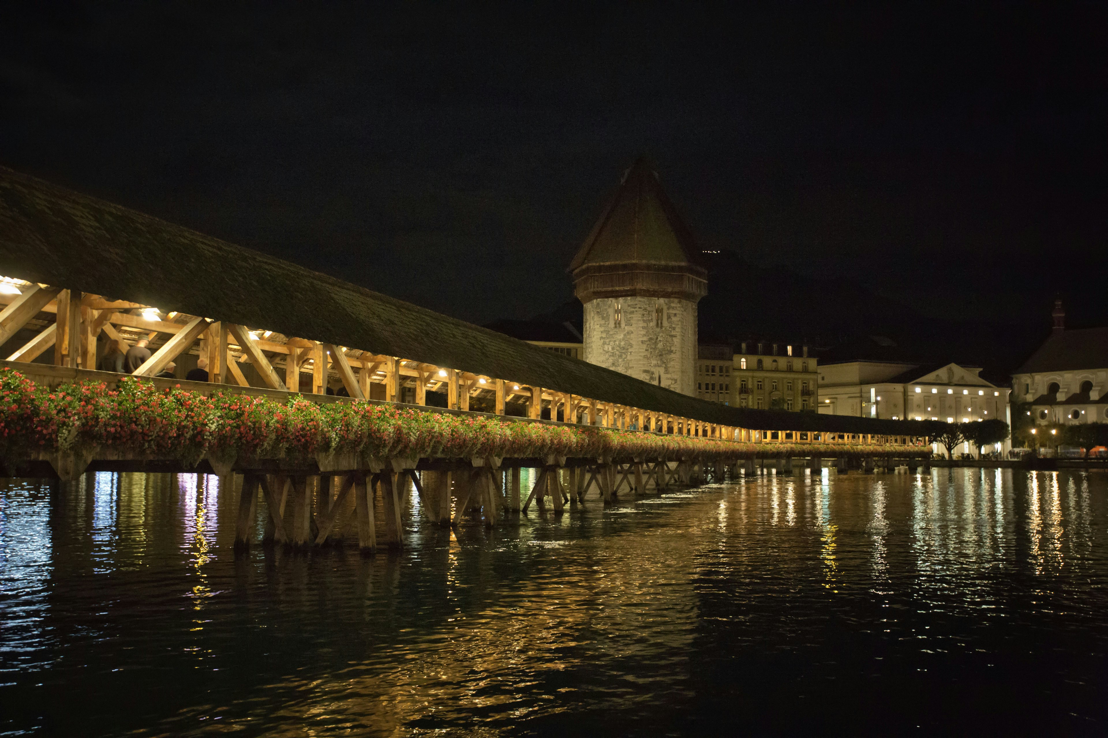 Vista notturna del Ponte della Cappella a Lucerna con riflessi sull'acqua