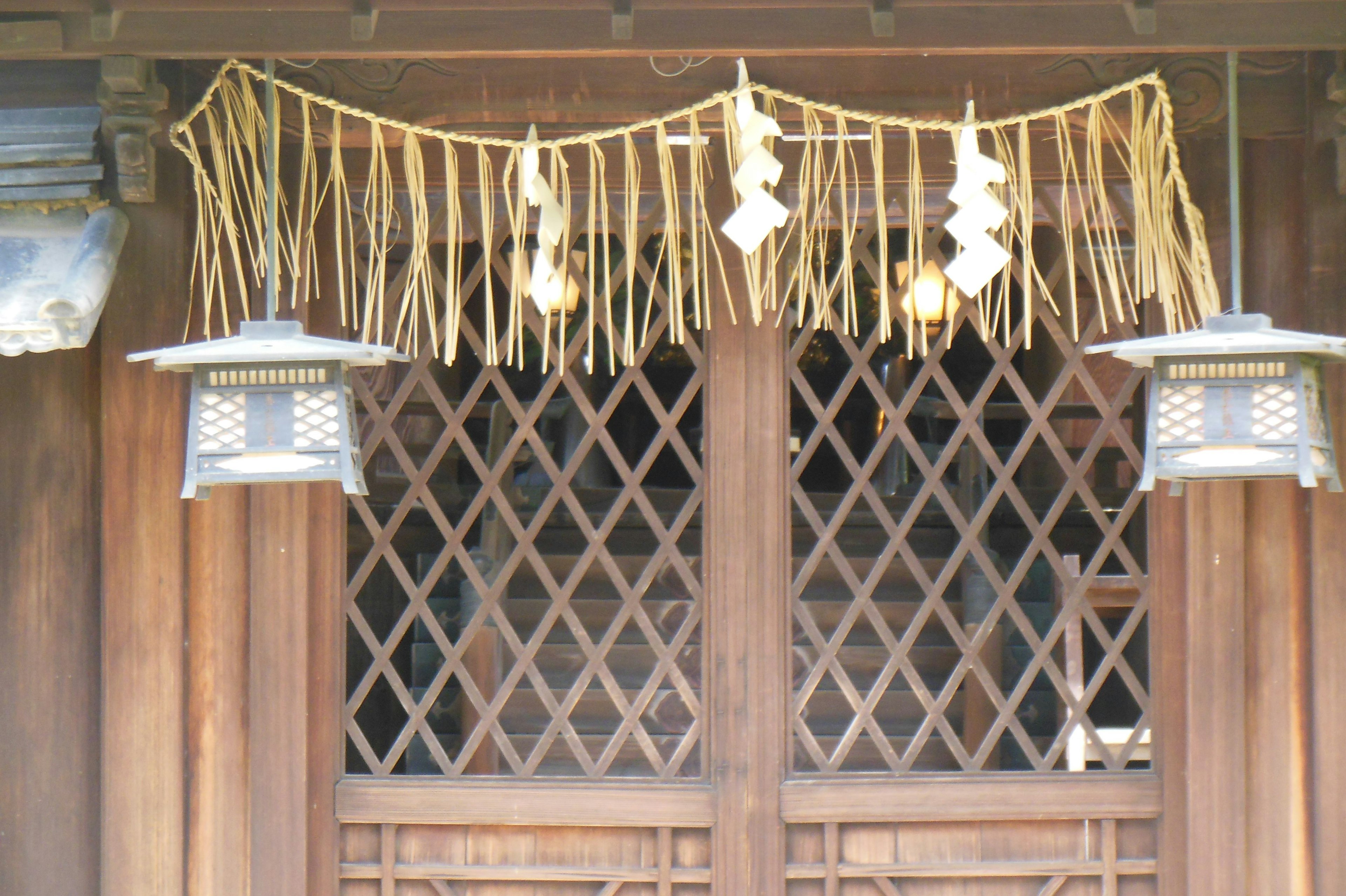 Exterior de un edificio tradicional de madera con puerta de madera y decoraciones de bambú