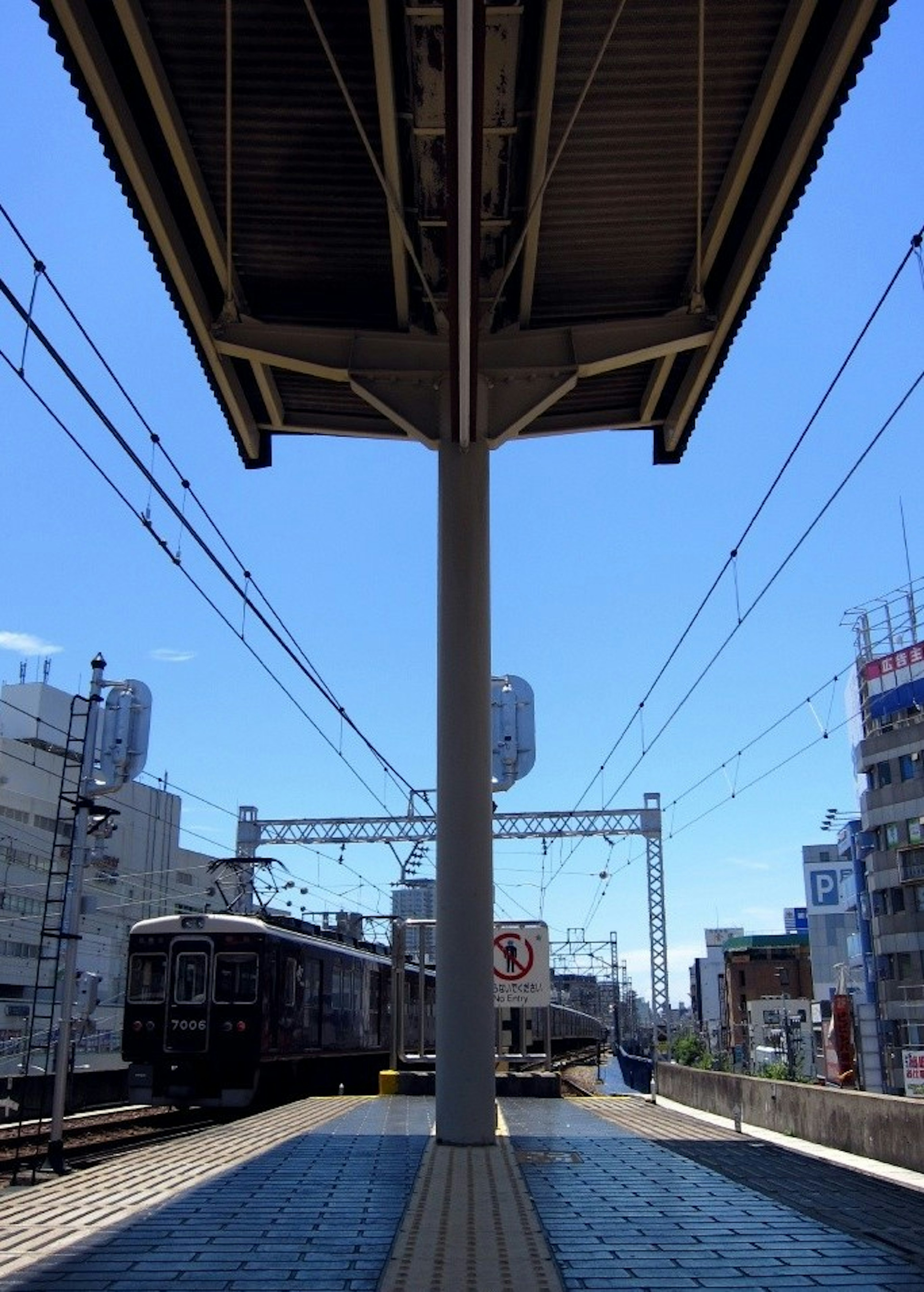 Vista de trenes y cielo azul desde una plataforma de tren