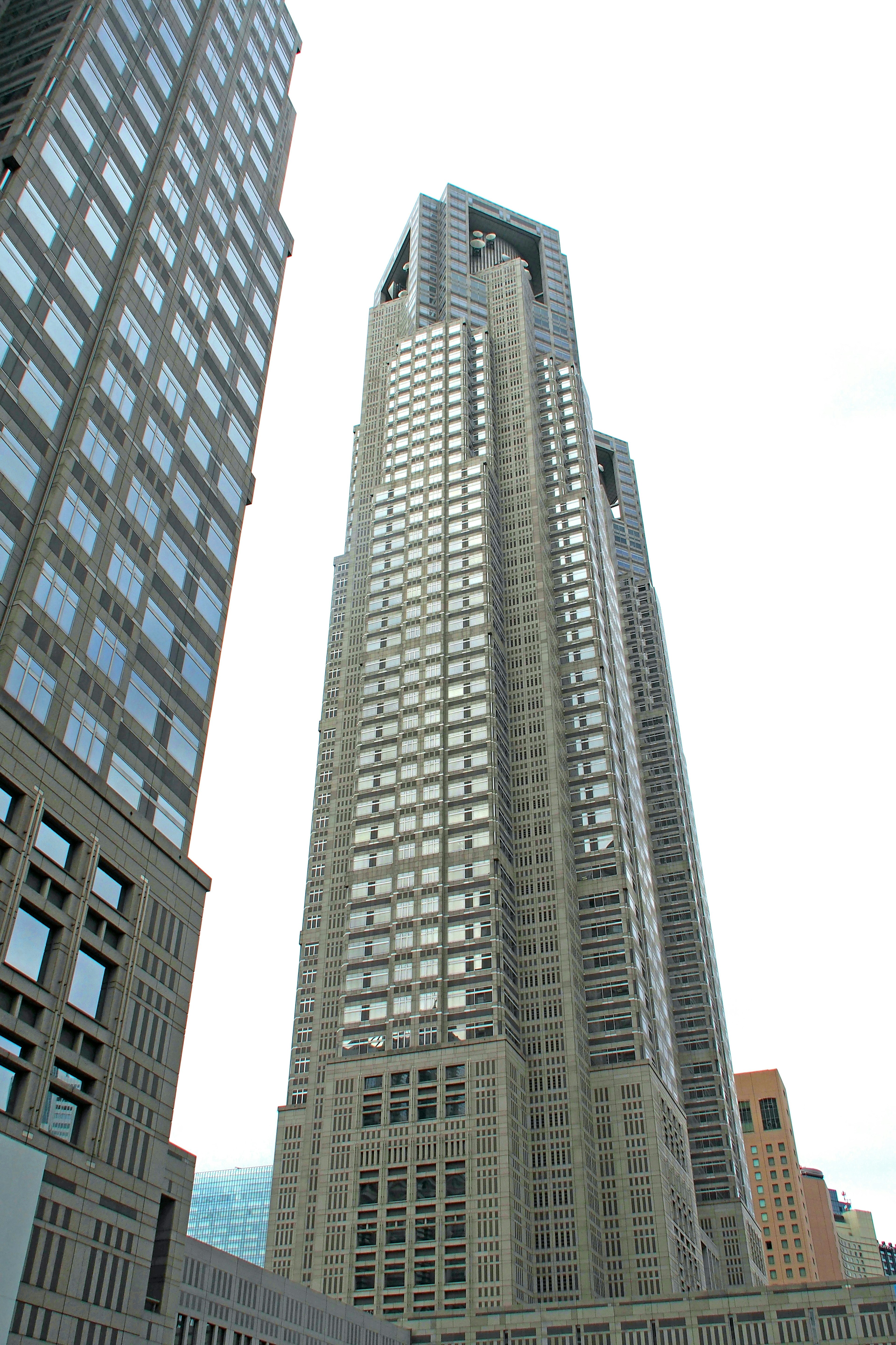 Tampilan luar gedung pencakar langit di Shinjuku, desain modern, fasad abu-abu