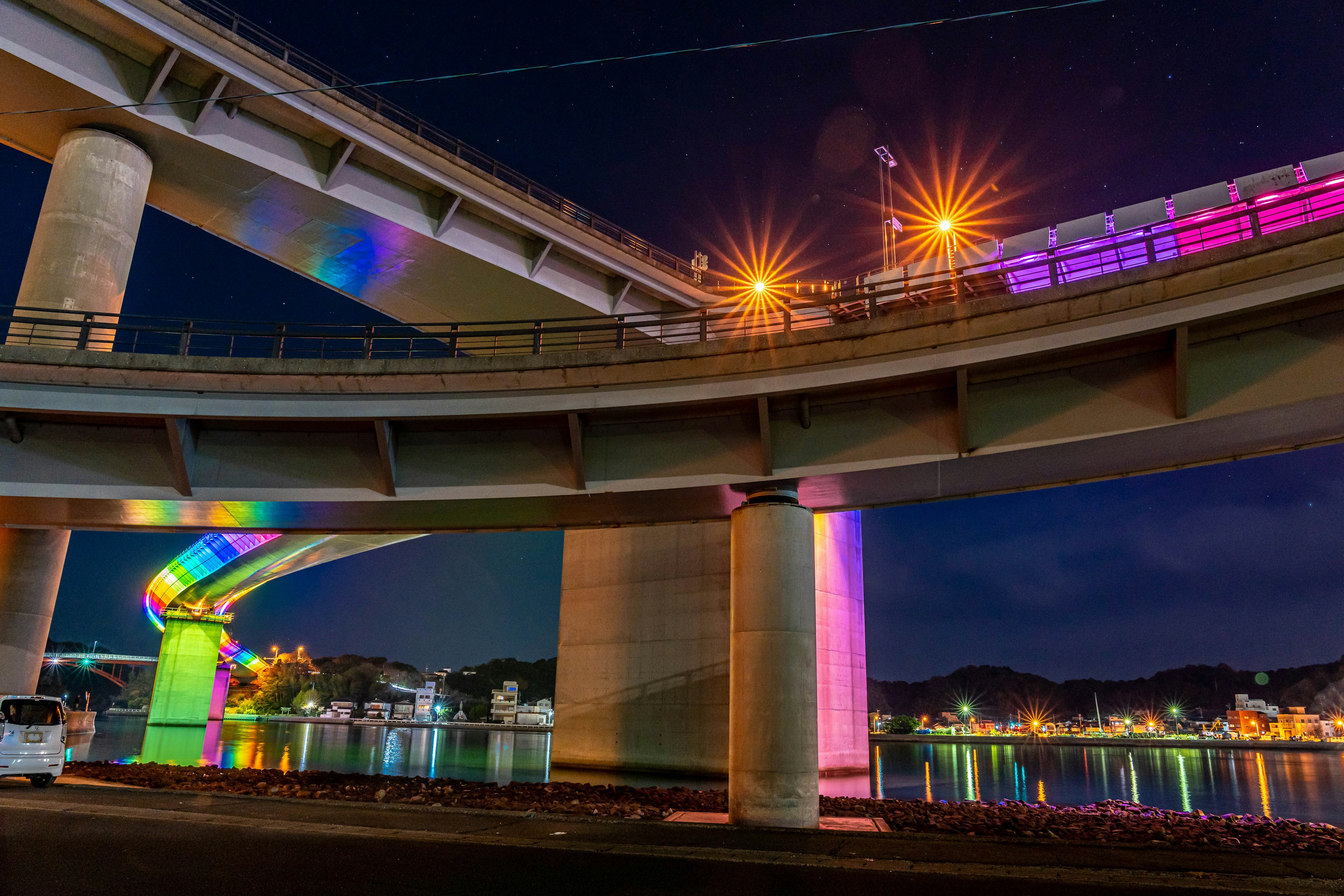 Colorful lighting and reflections under a bridge at night