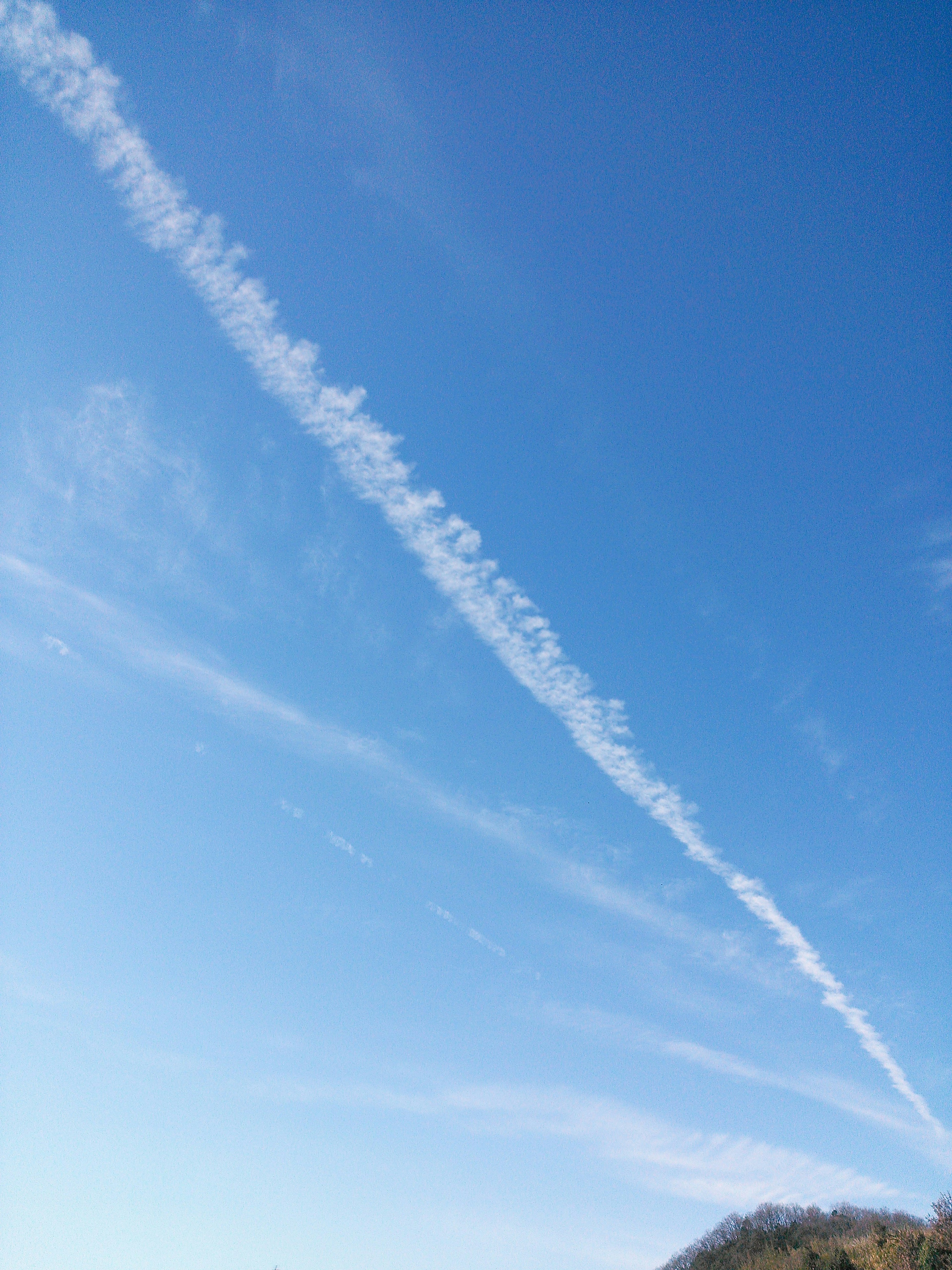 Un cielo azul claro con una estela blanca que se extiende a través de él