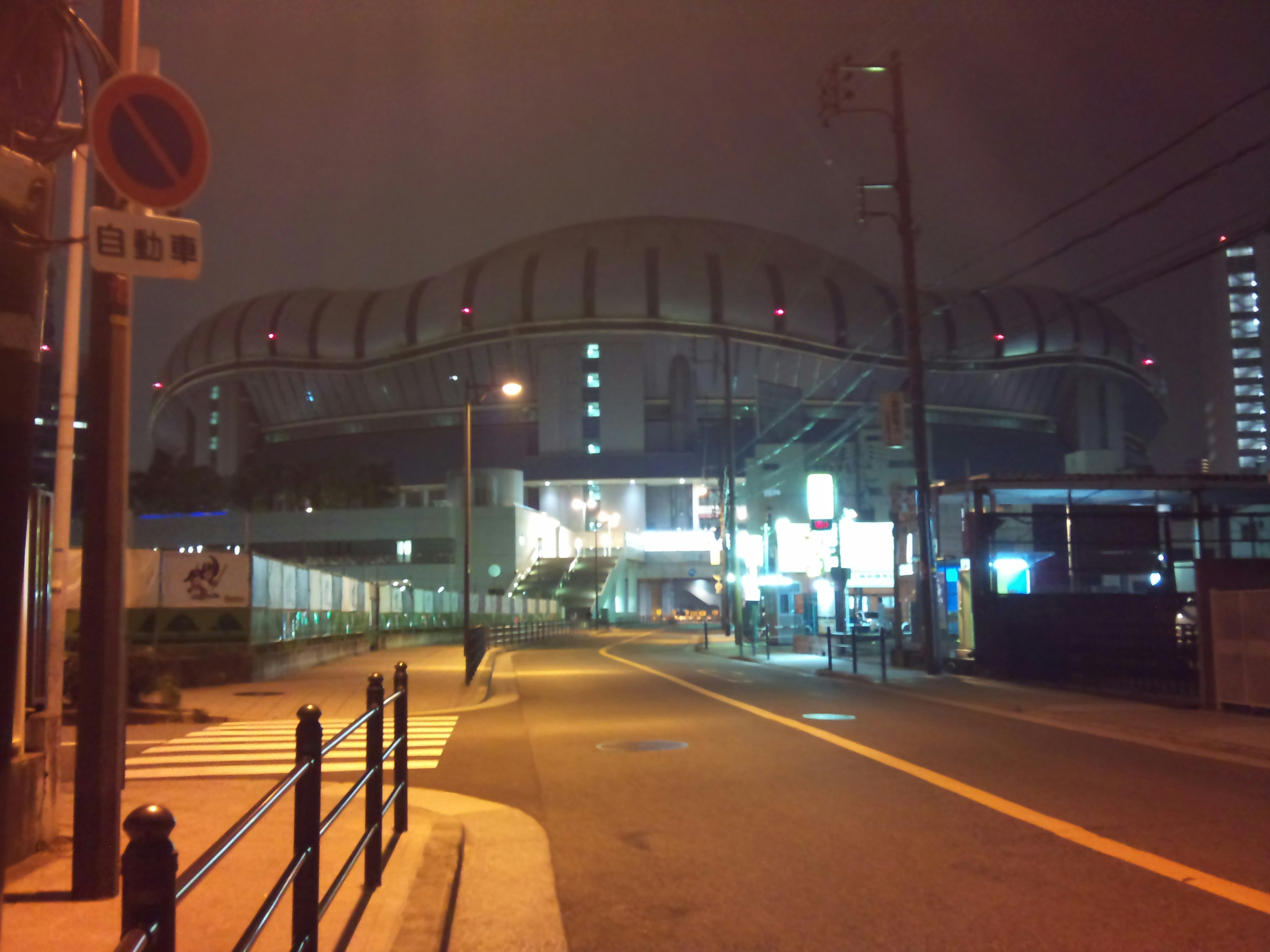 夜の都市風景にあるスタジアムの外観と街灯