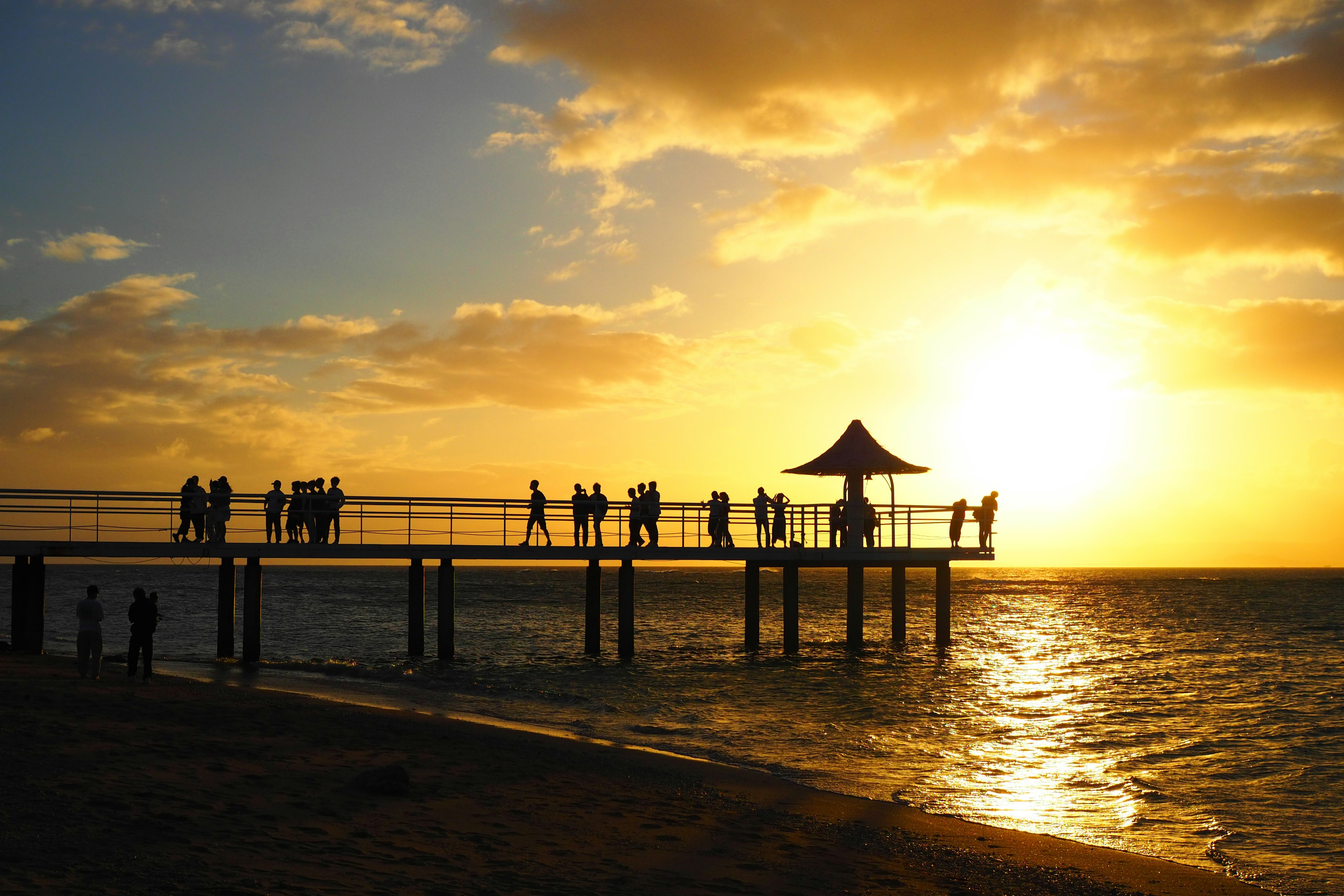 Silueta de personas en un muelle al atardecer