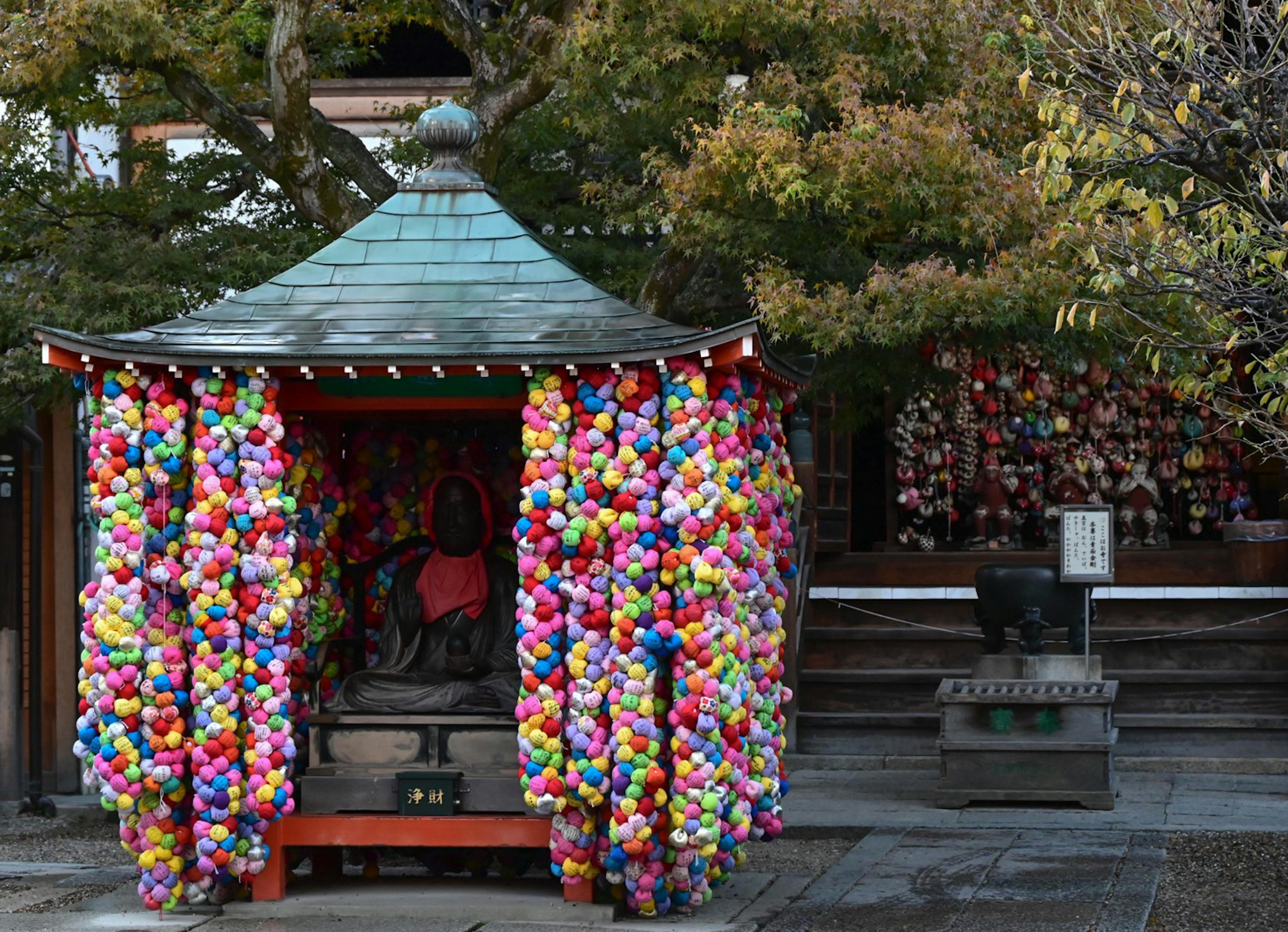 色とりどりの花の飾りで覆われた小さな神社の建物