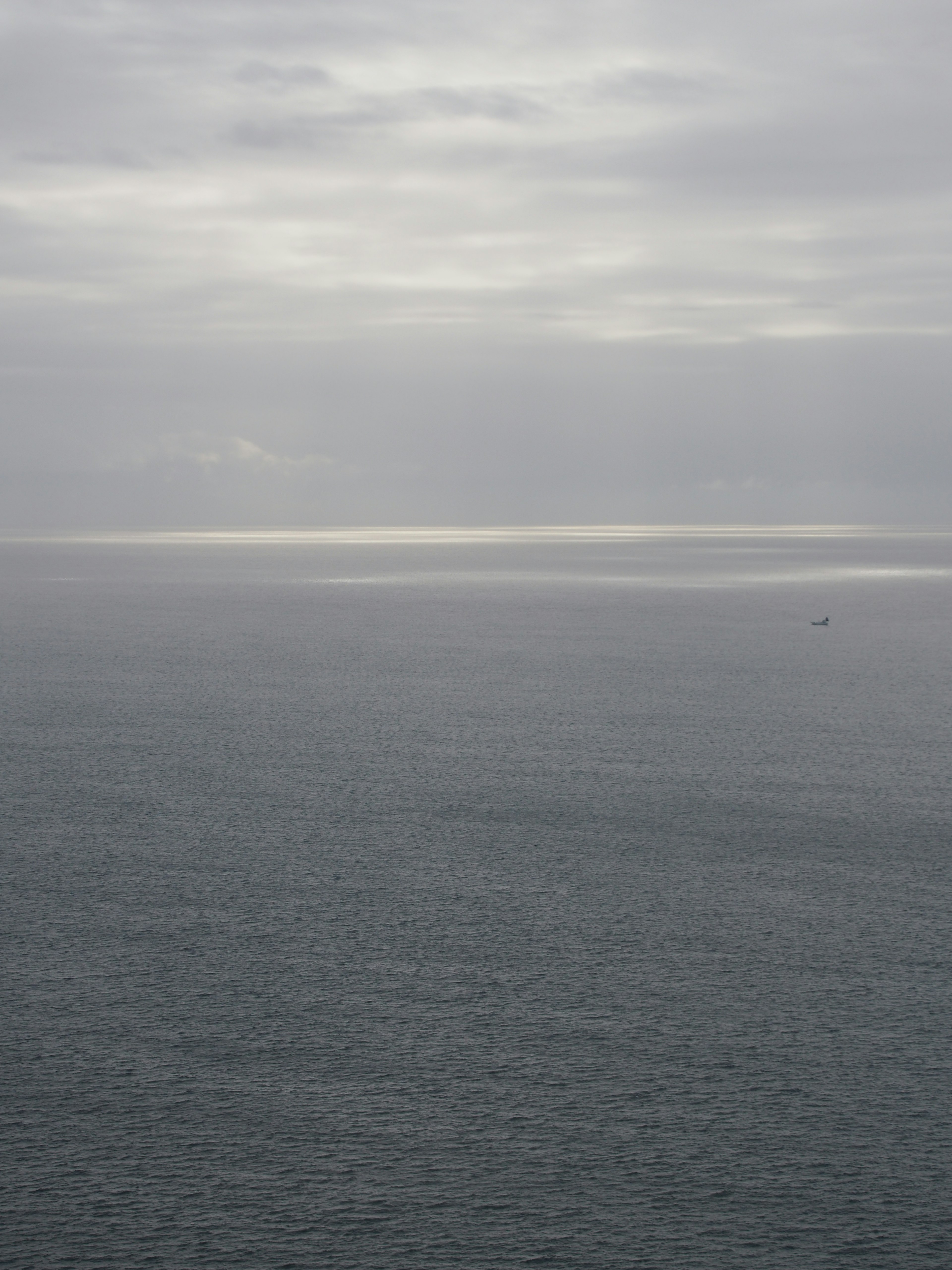 Mer calme et ciel nuageux avec lumière réfléchie sur la surface de l'eau