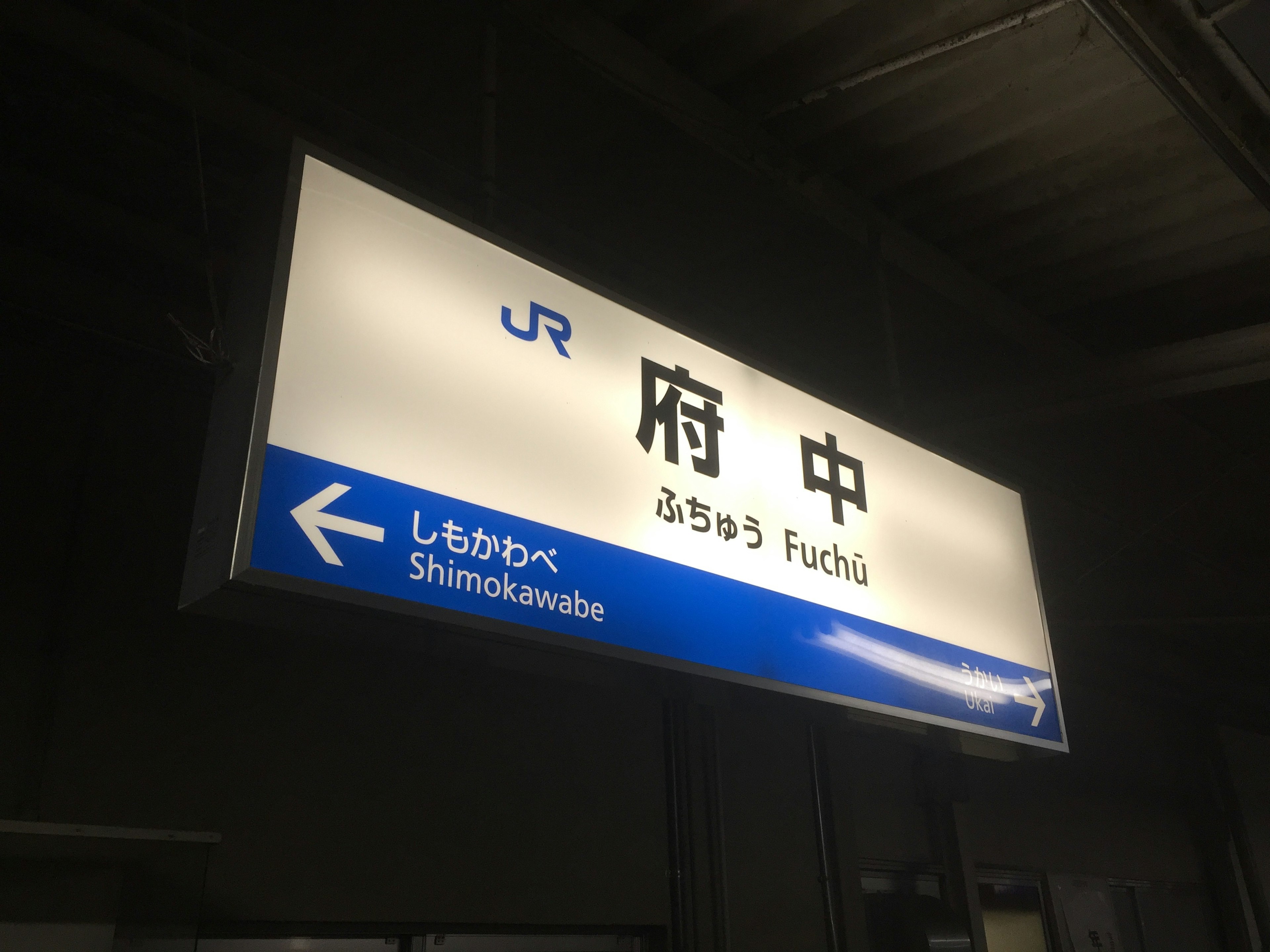 Schild der Station Fuchu mit blauem und weißem Design