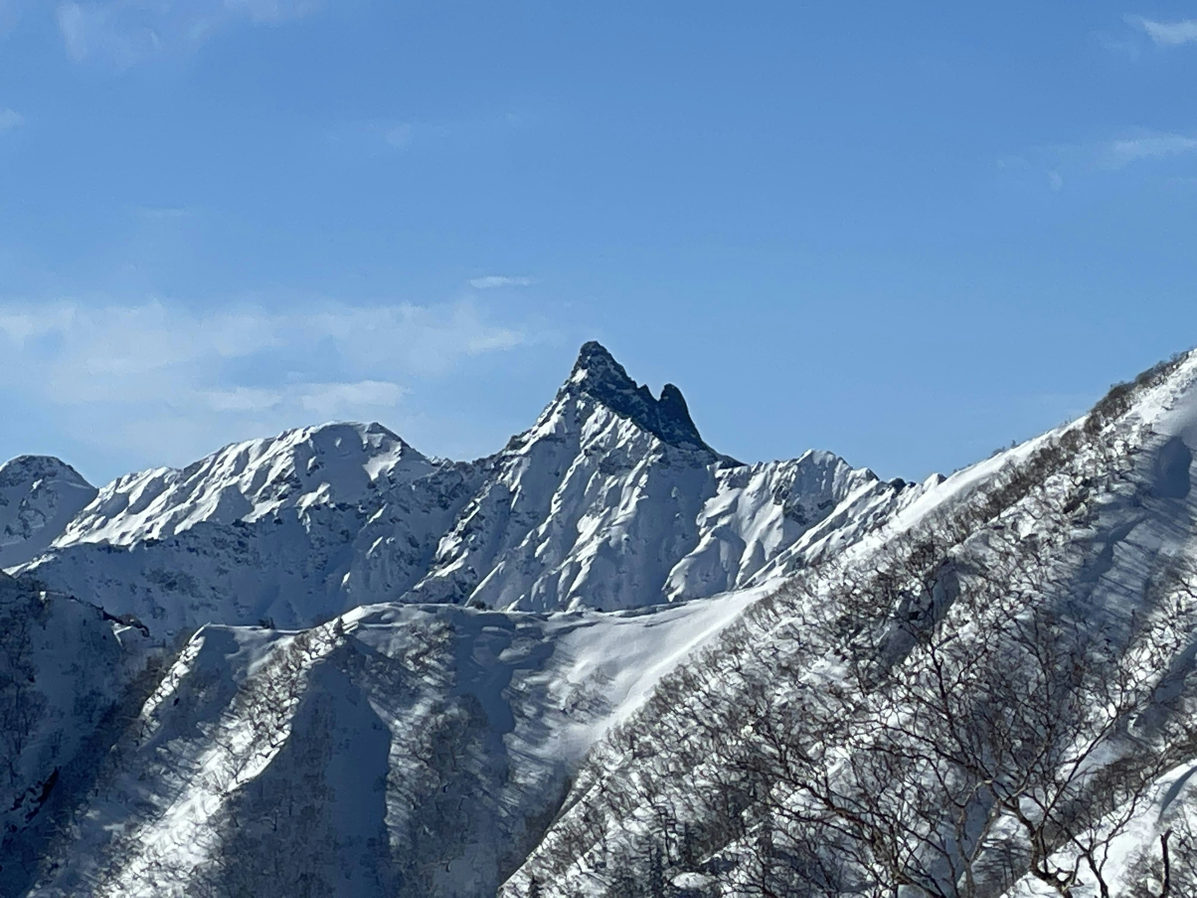 Snow-covered mountain peaks under a clear blue sky