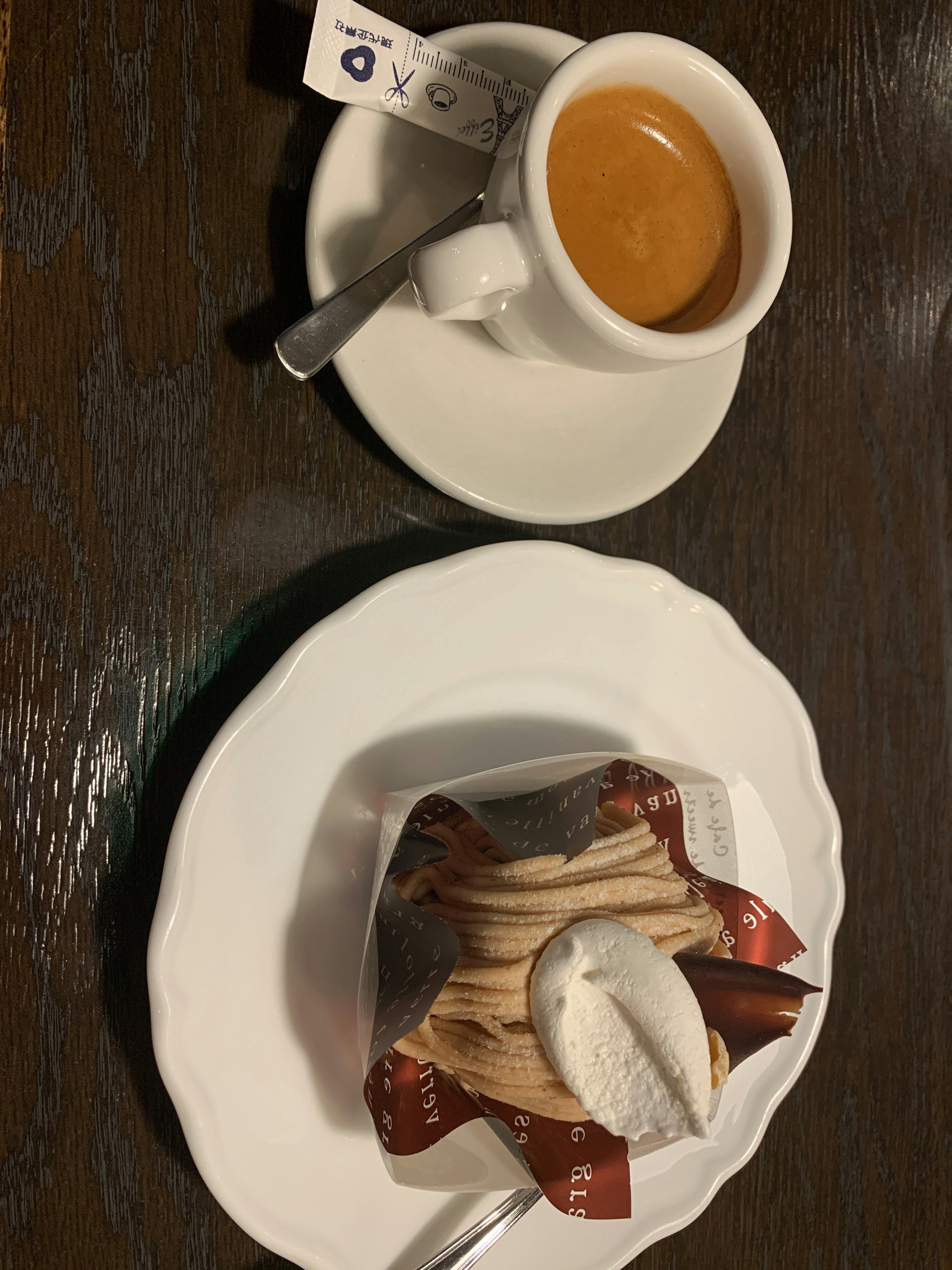 Caffè espresso servito con una torta a strati guarnita di crema