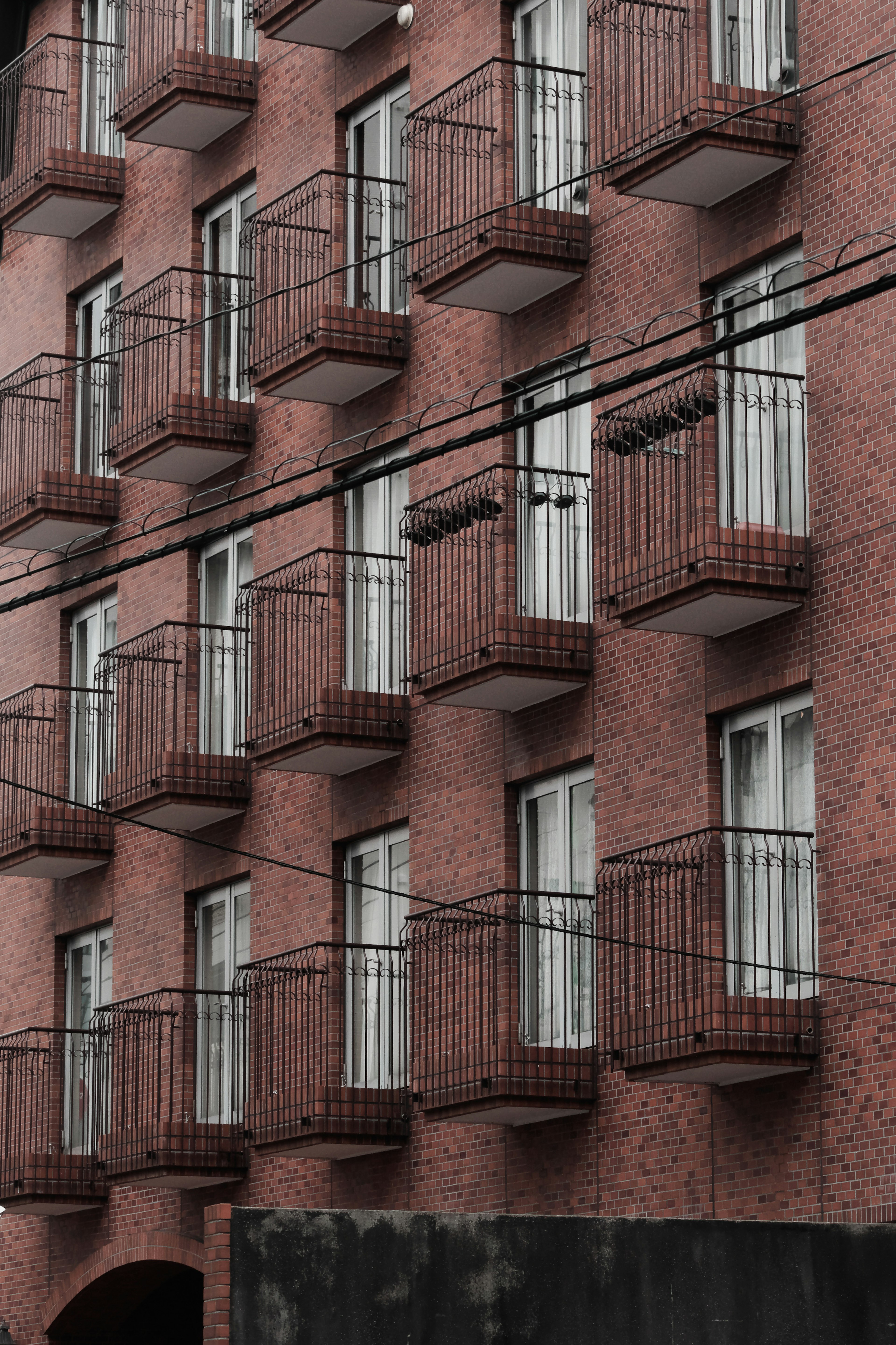 Apartment building with red exterior featuring multiple balconies