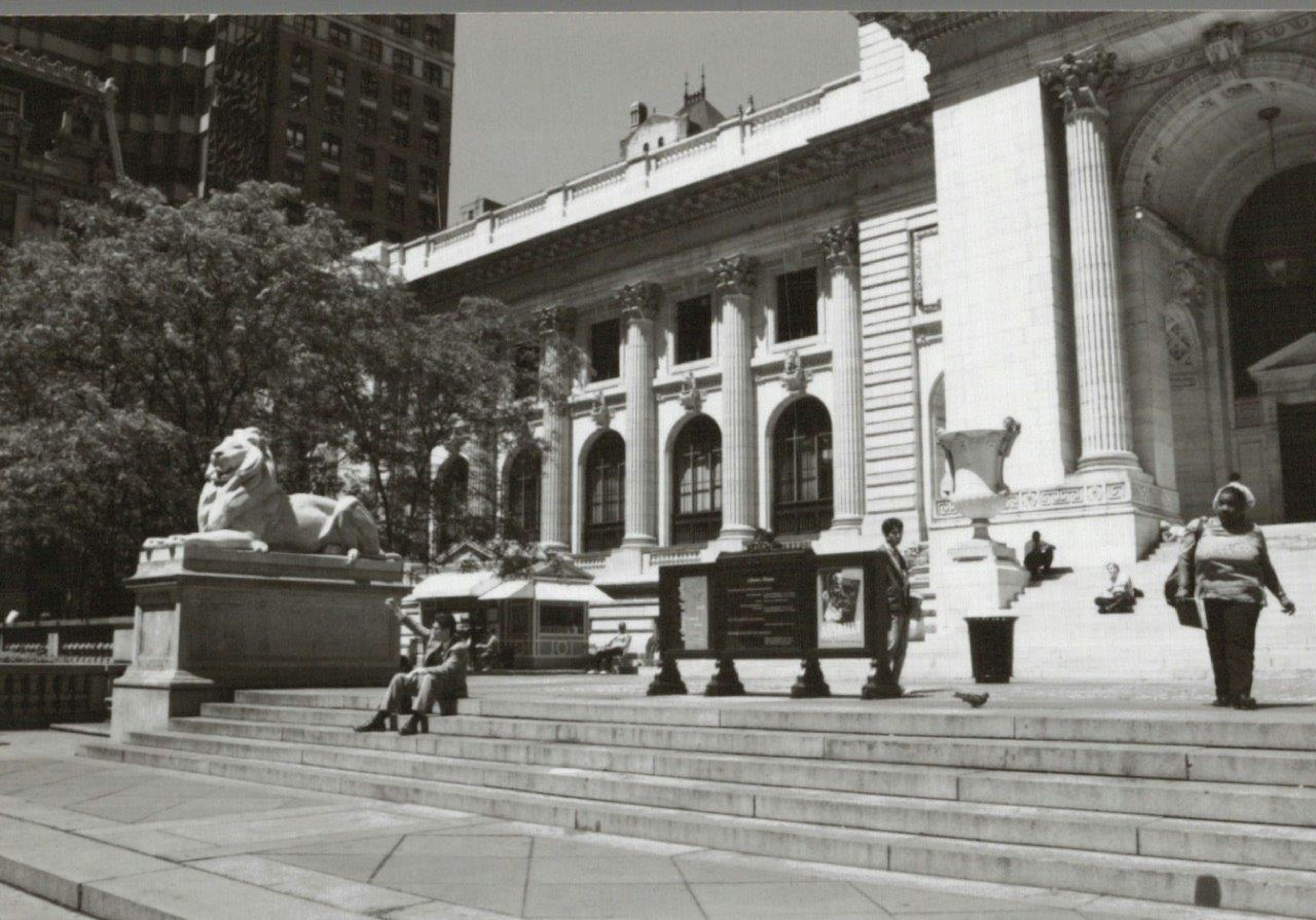 Black and white photograph of the New York Public Library with people on the steps