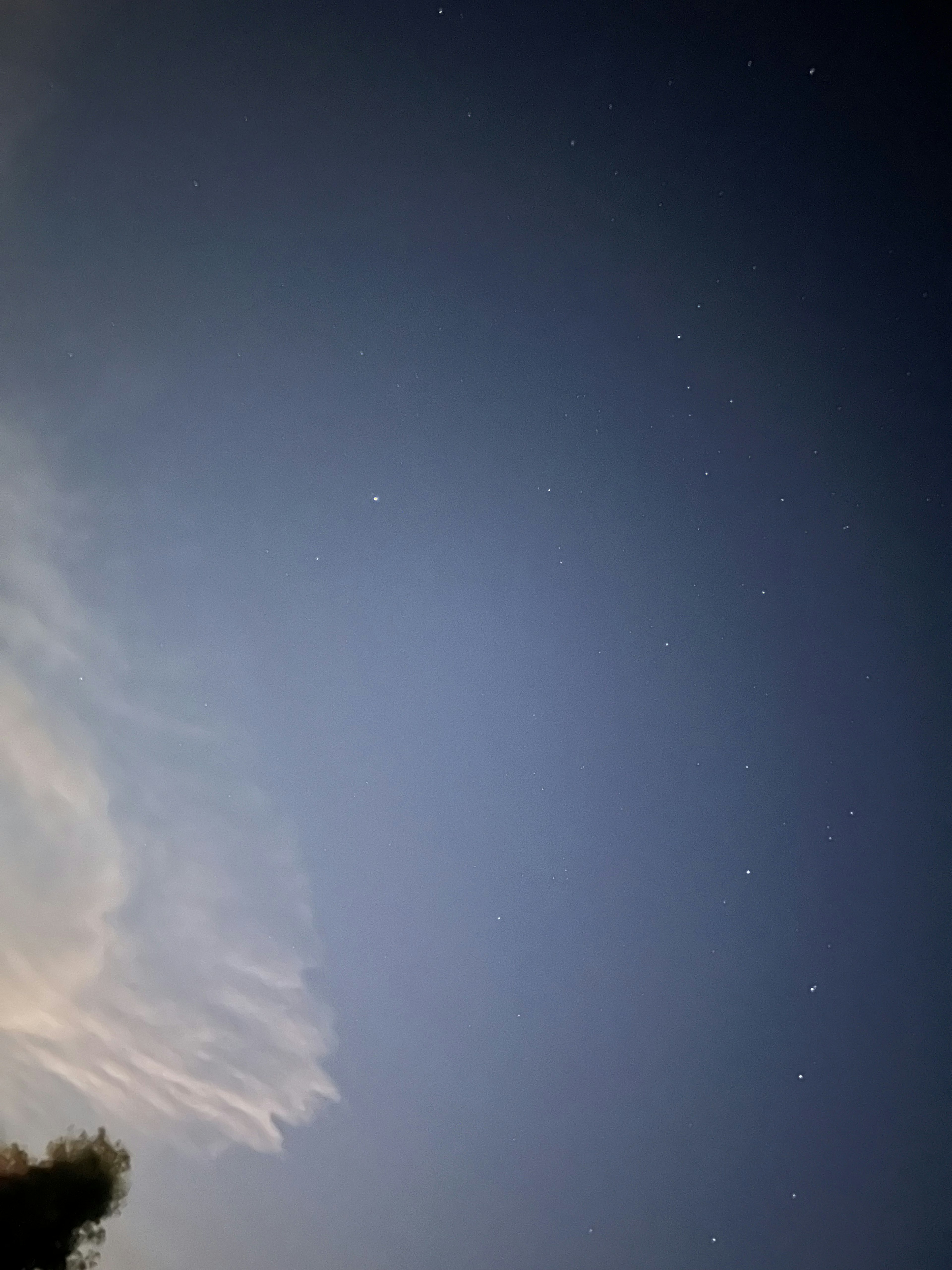 Night sky filled with scattered stars and part of a cloud