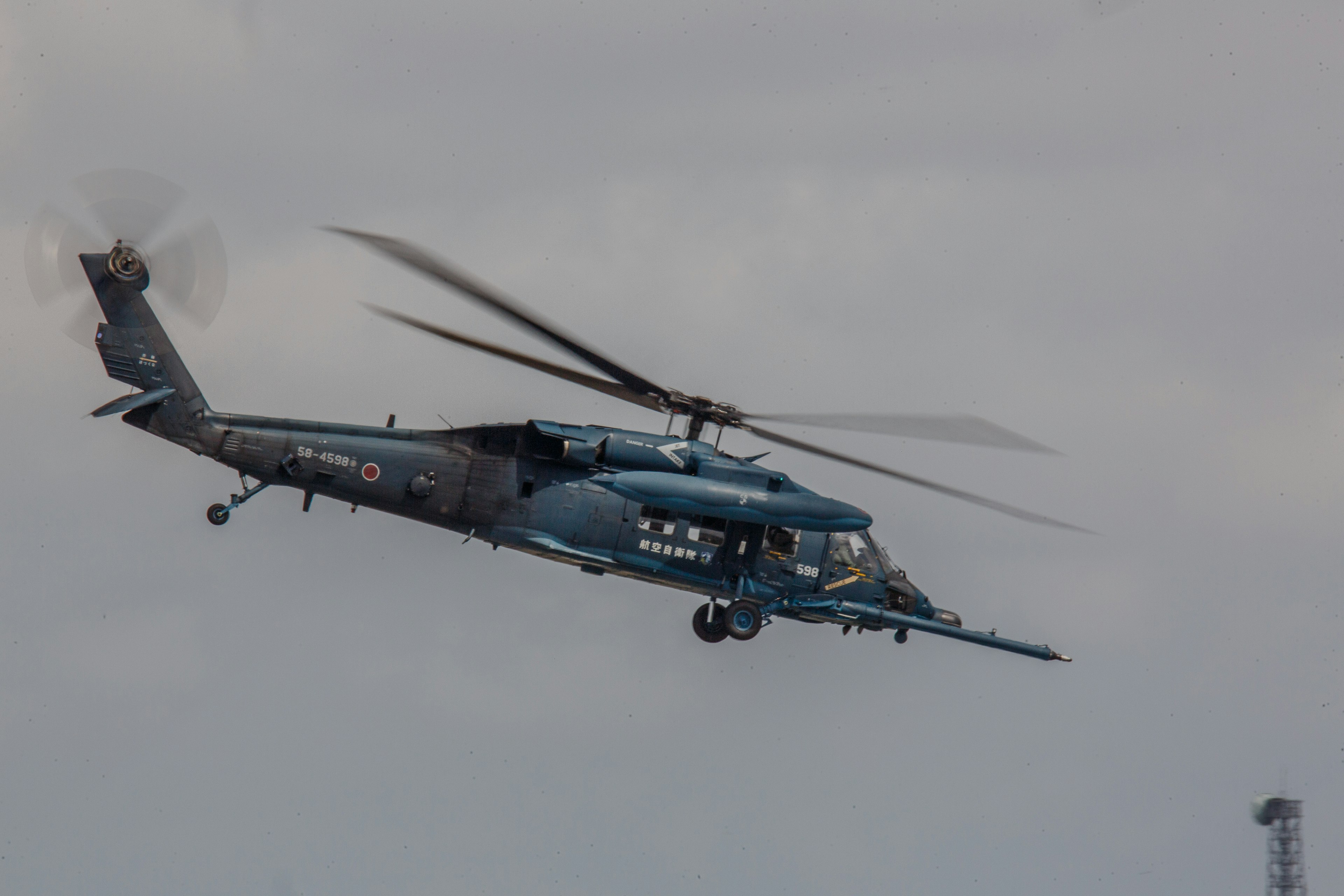 A blue helicopter hovering in the air