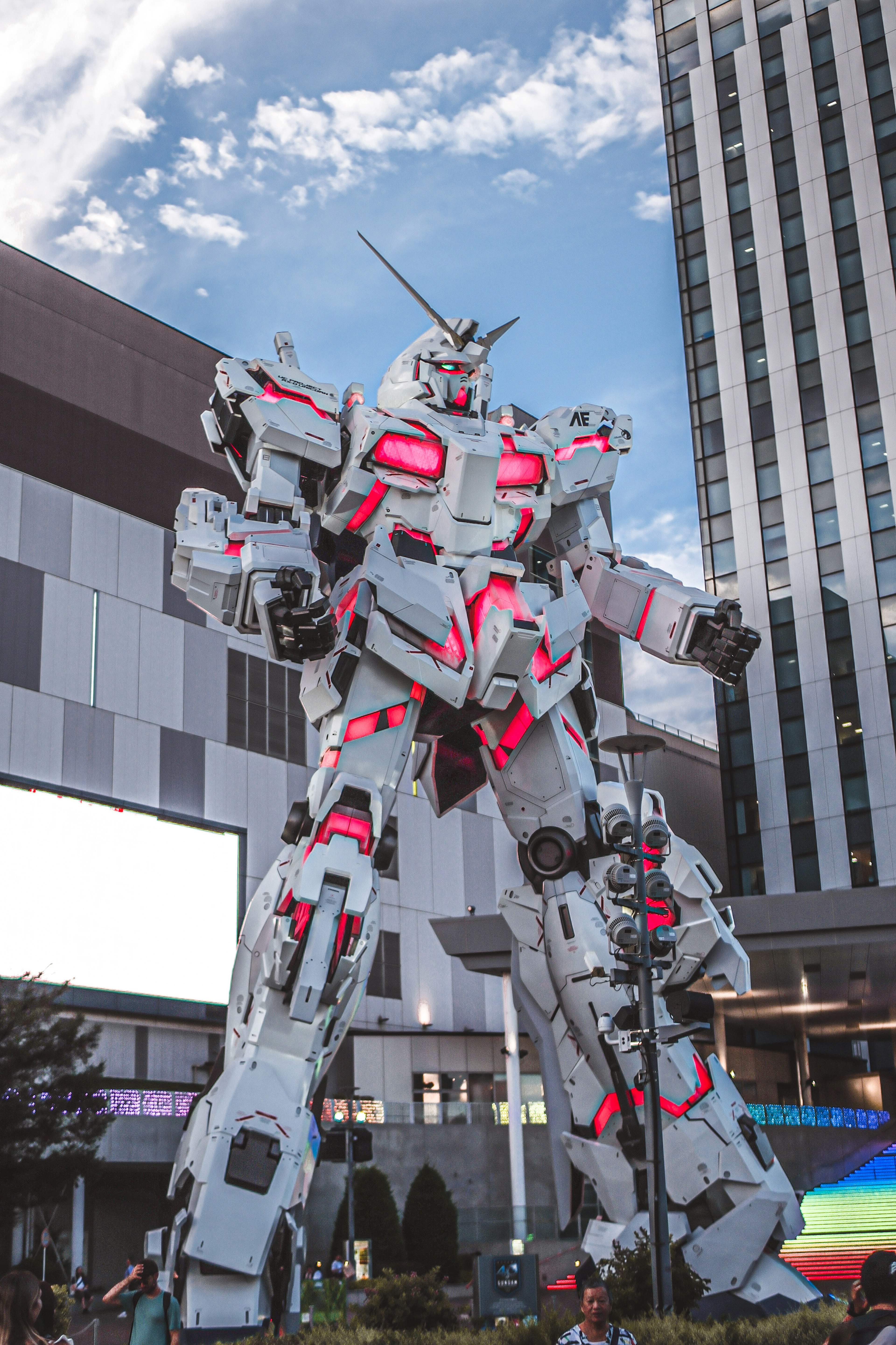 A giant Gundam statue towering in an urban setting