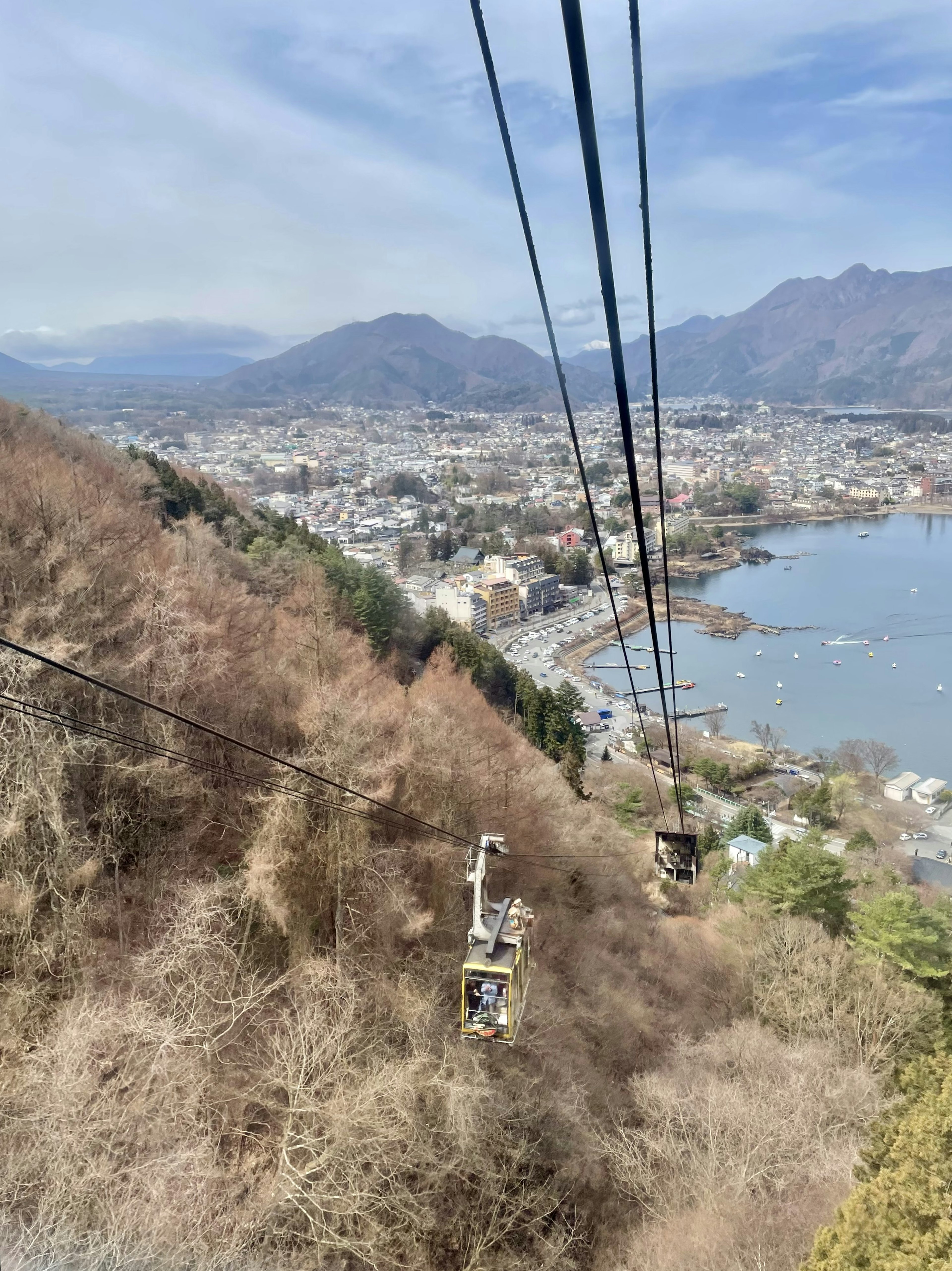 从山上俯瞰城市和湖泊的景色，带有缆车