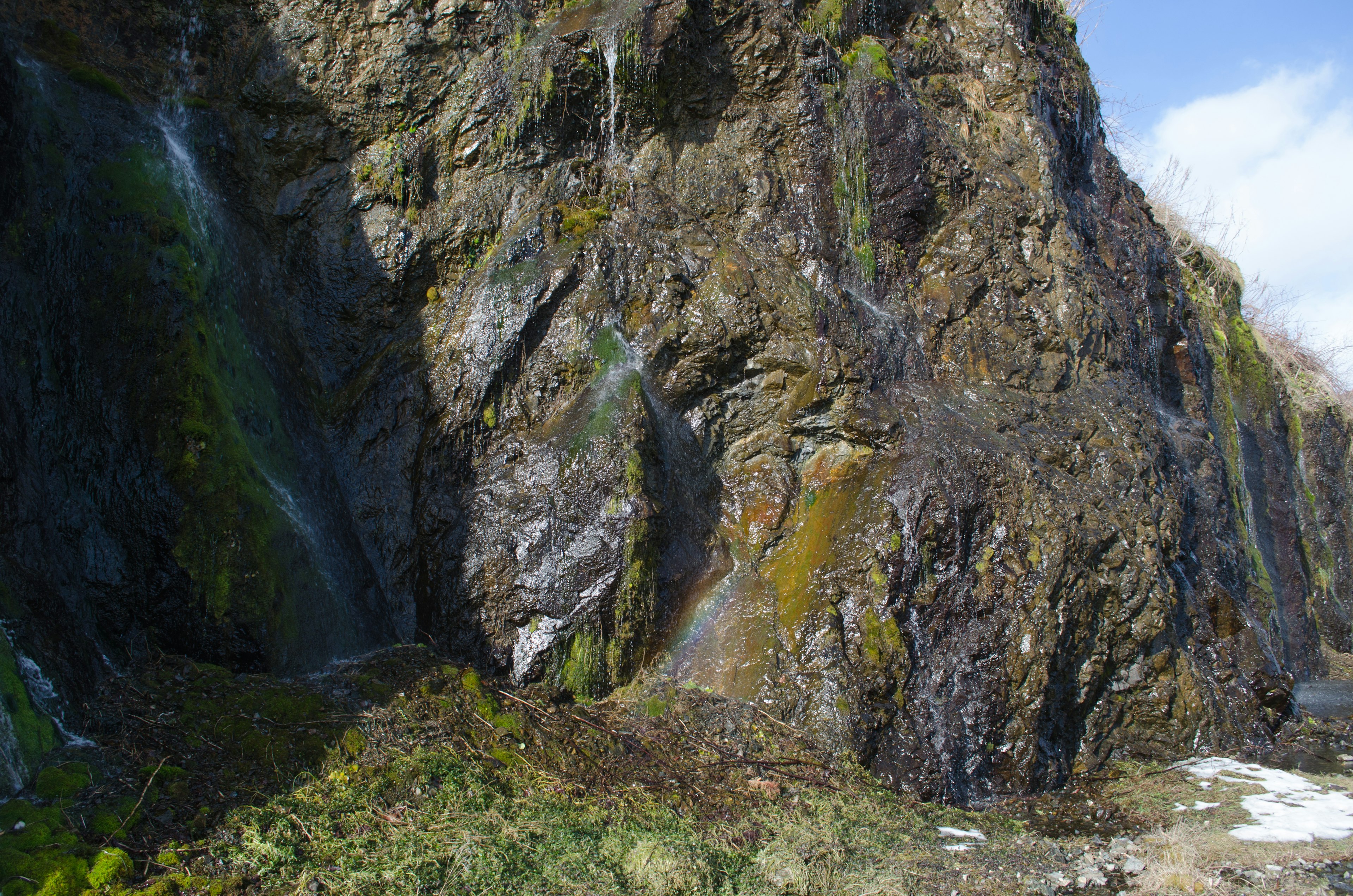 Malersicher Blick auf Wasserfälle, die von felsigen Klippen mit üppigem grünem Moos herabfallen