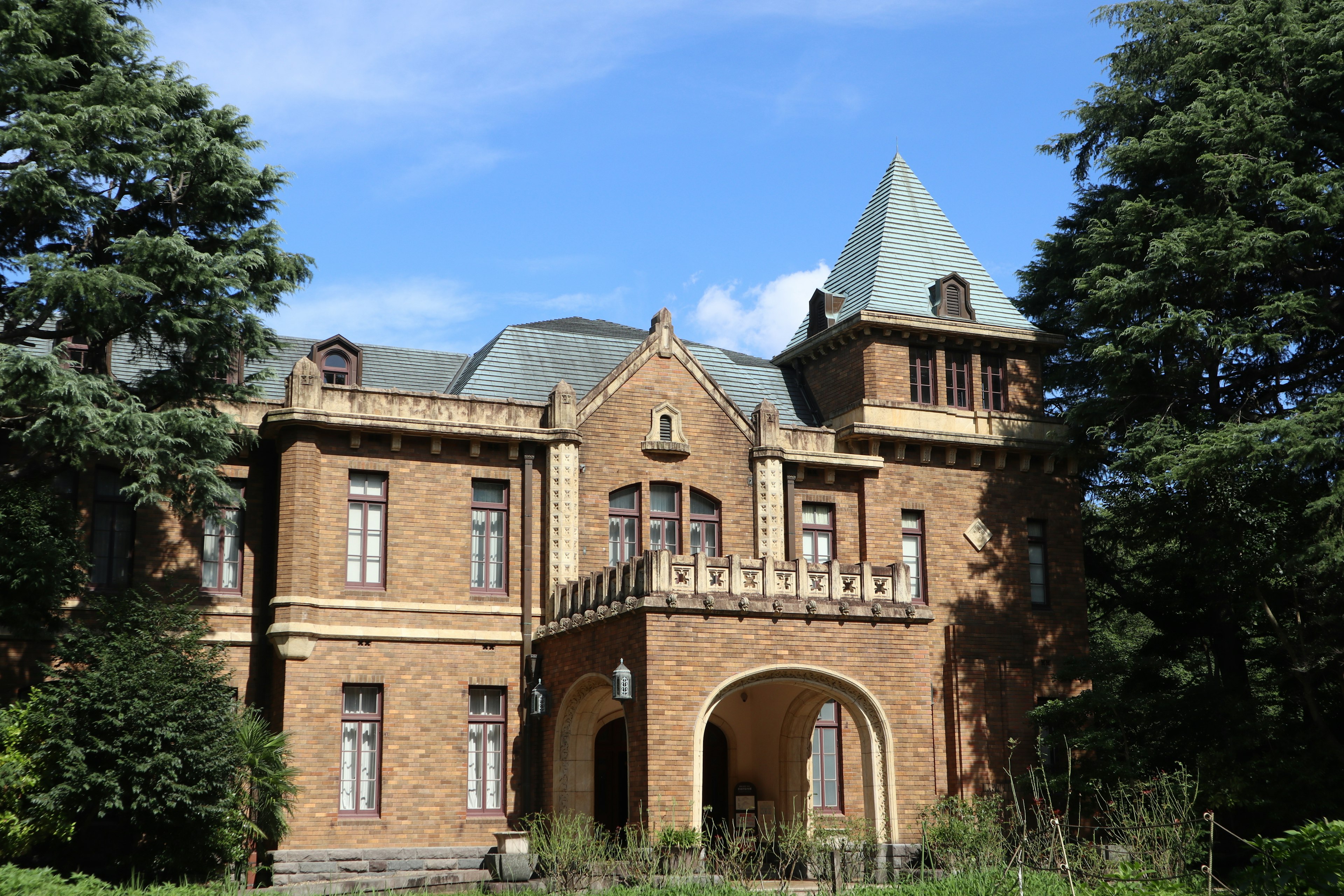 Beautiful brick mansion surrounded by green trees and blue sky