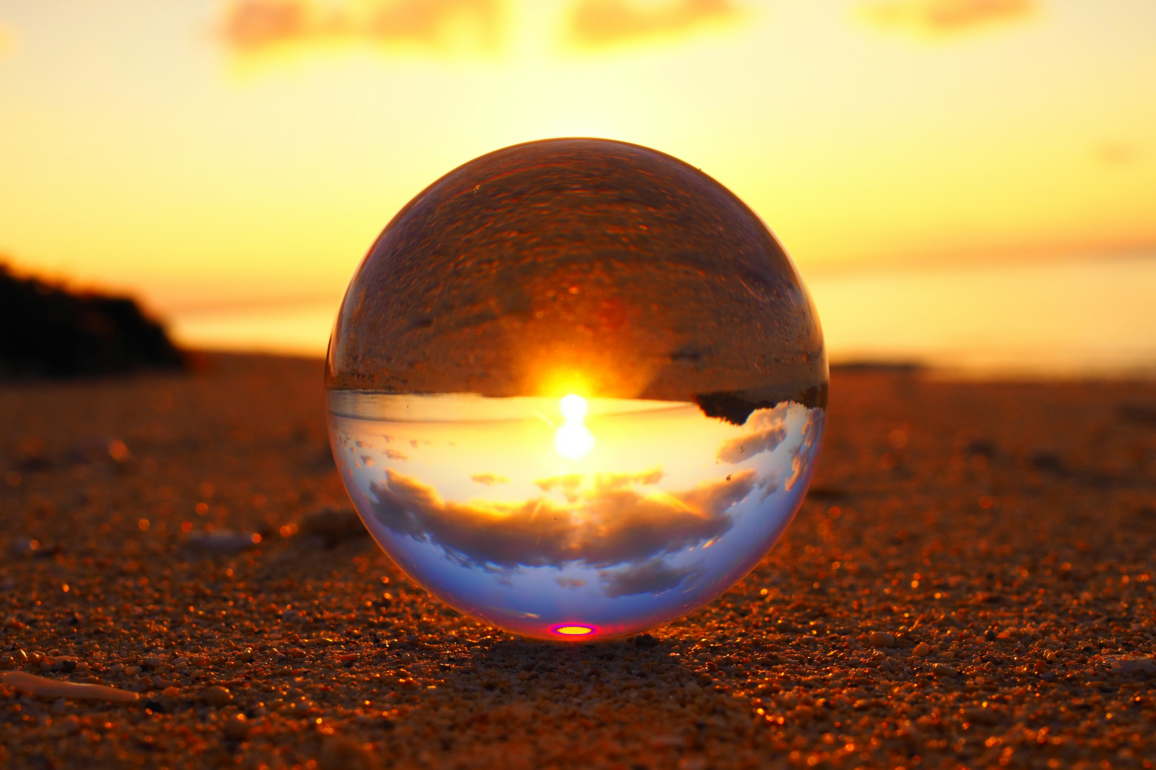 Bola de cristal reflejando el atardecer en la playa