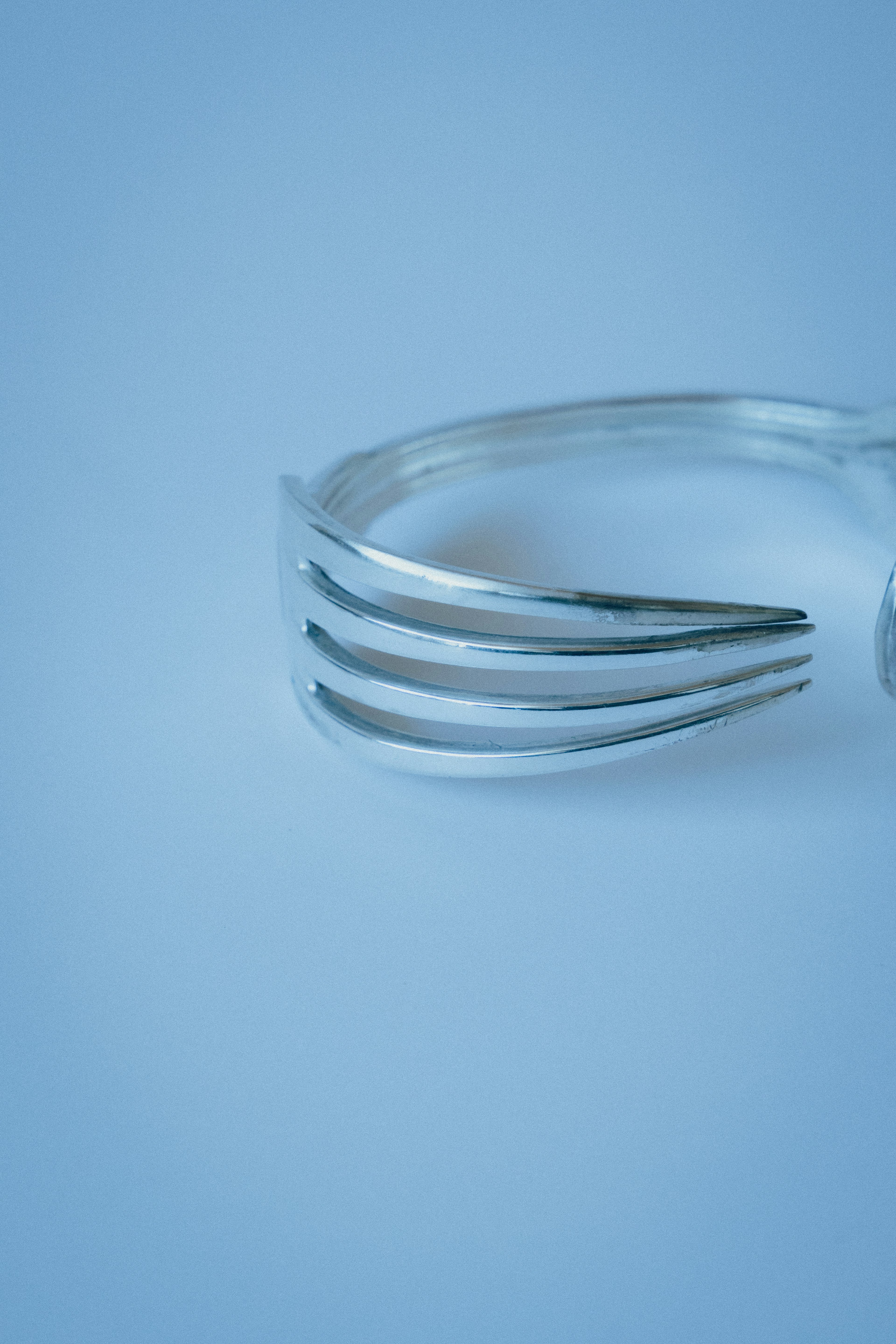 Metal fork ring on a blue background