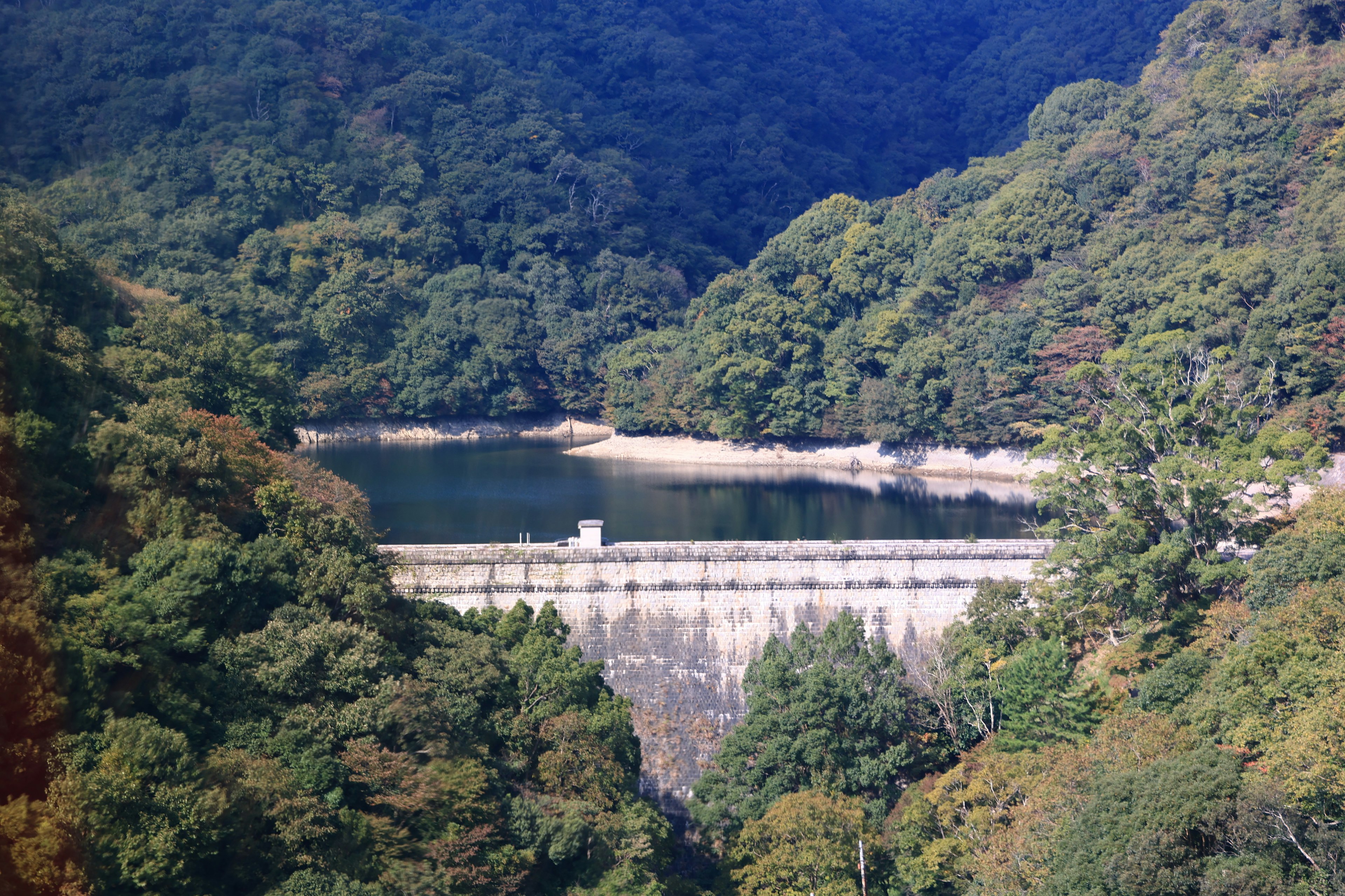 Vue panoramique d'un barrage entouré de montagnes verdoyantes