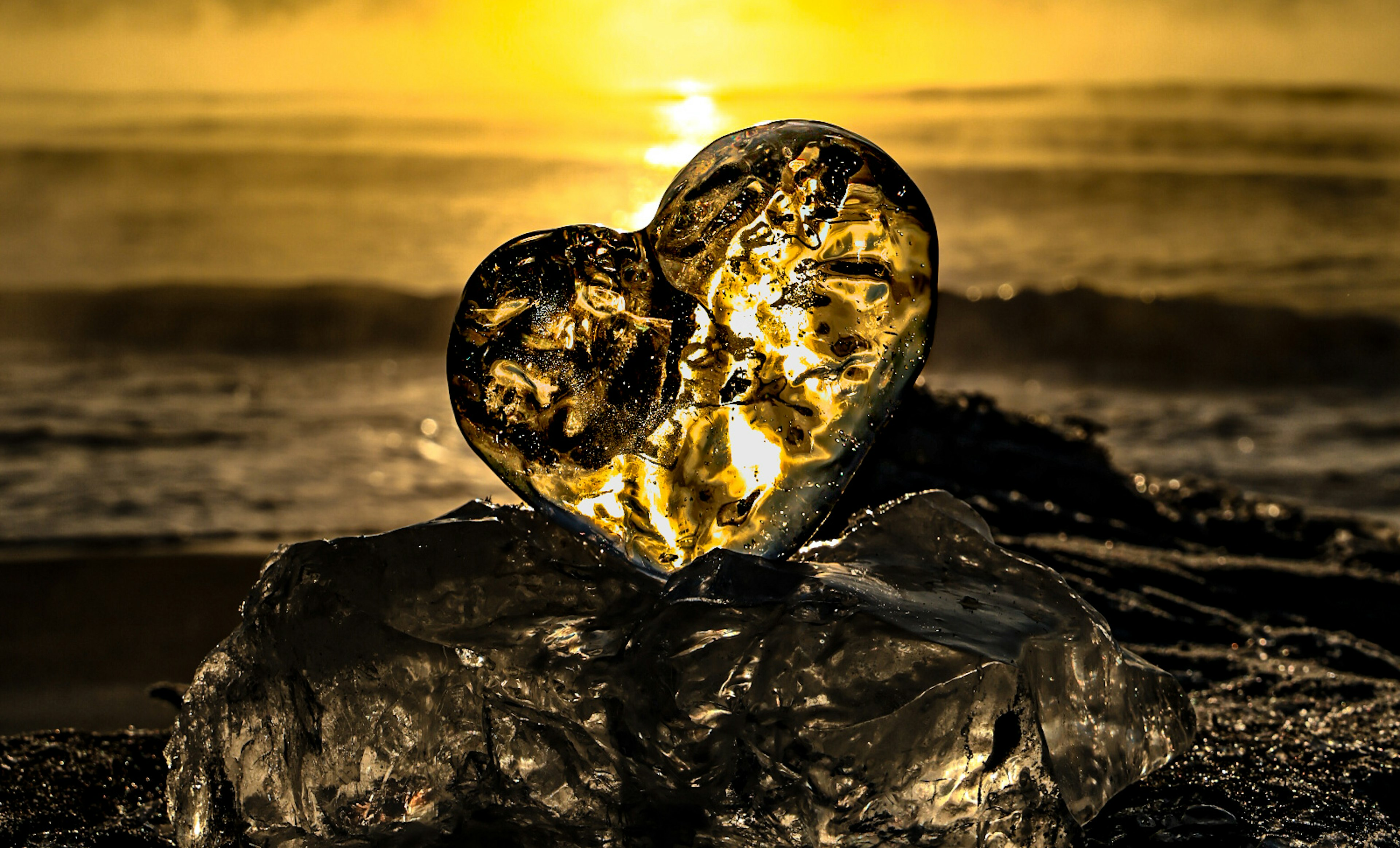 Heart-shaped rock on the beach with sunlight shining through