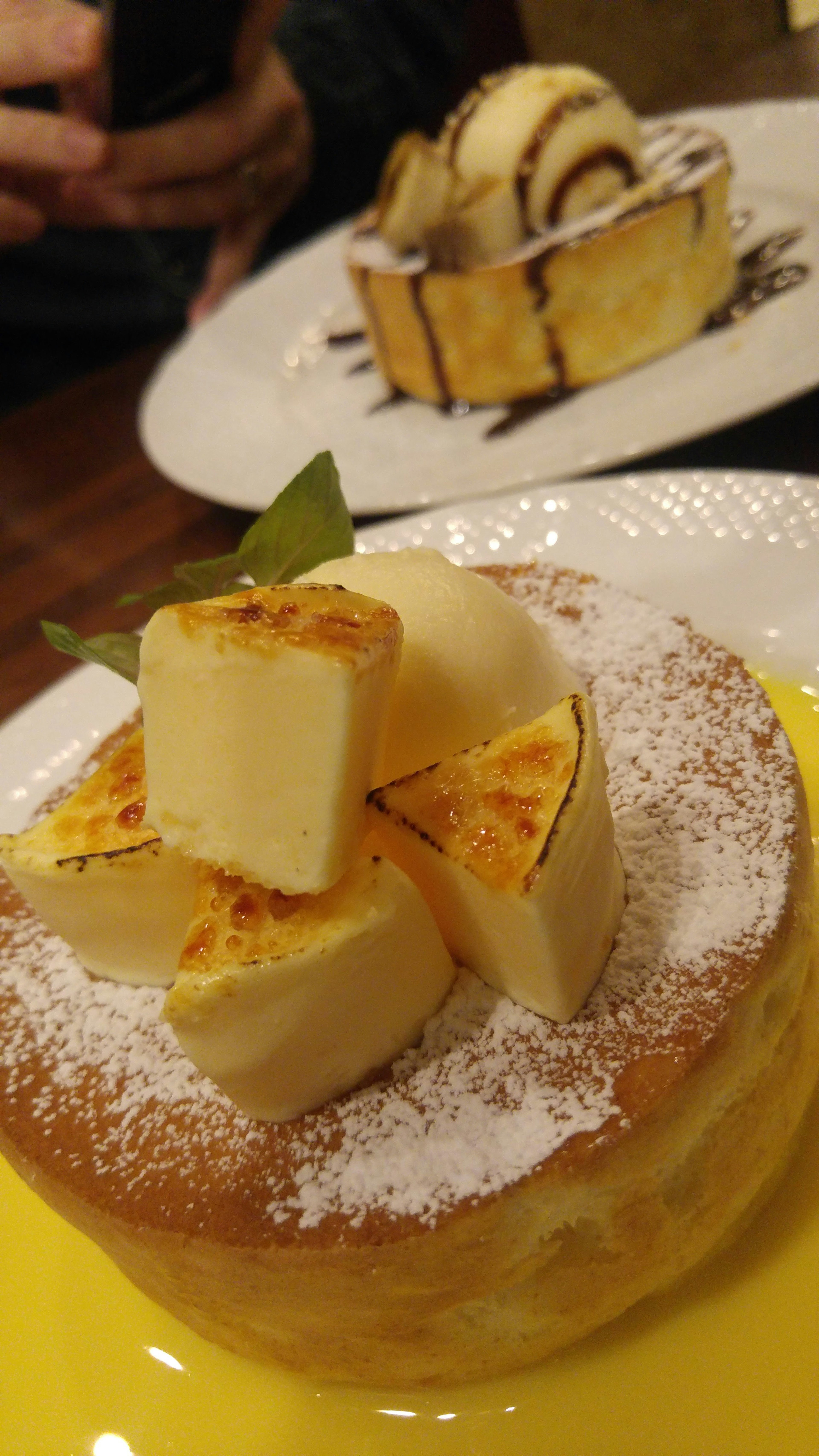 Fluffy cheesecake topped with square cheese pieces and powdered sugar