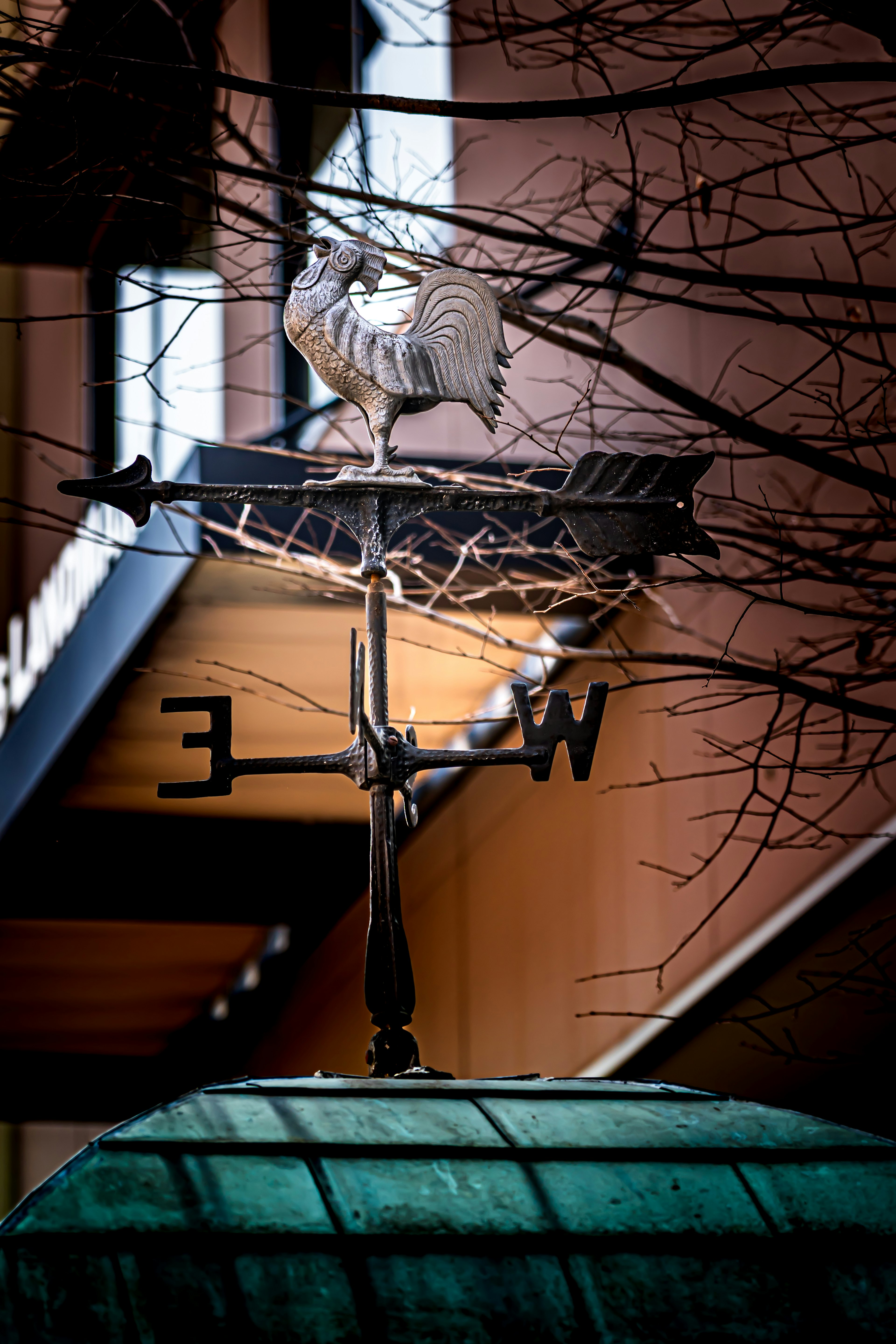 Decorative weather vane with a rooster indicating east and west directions