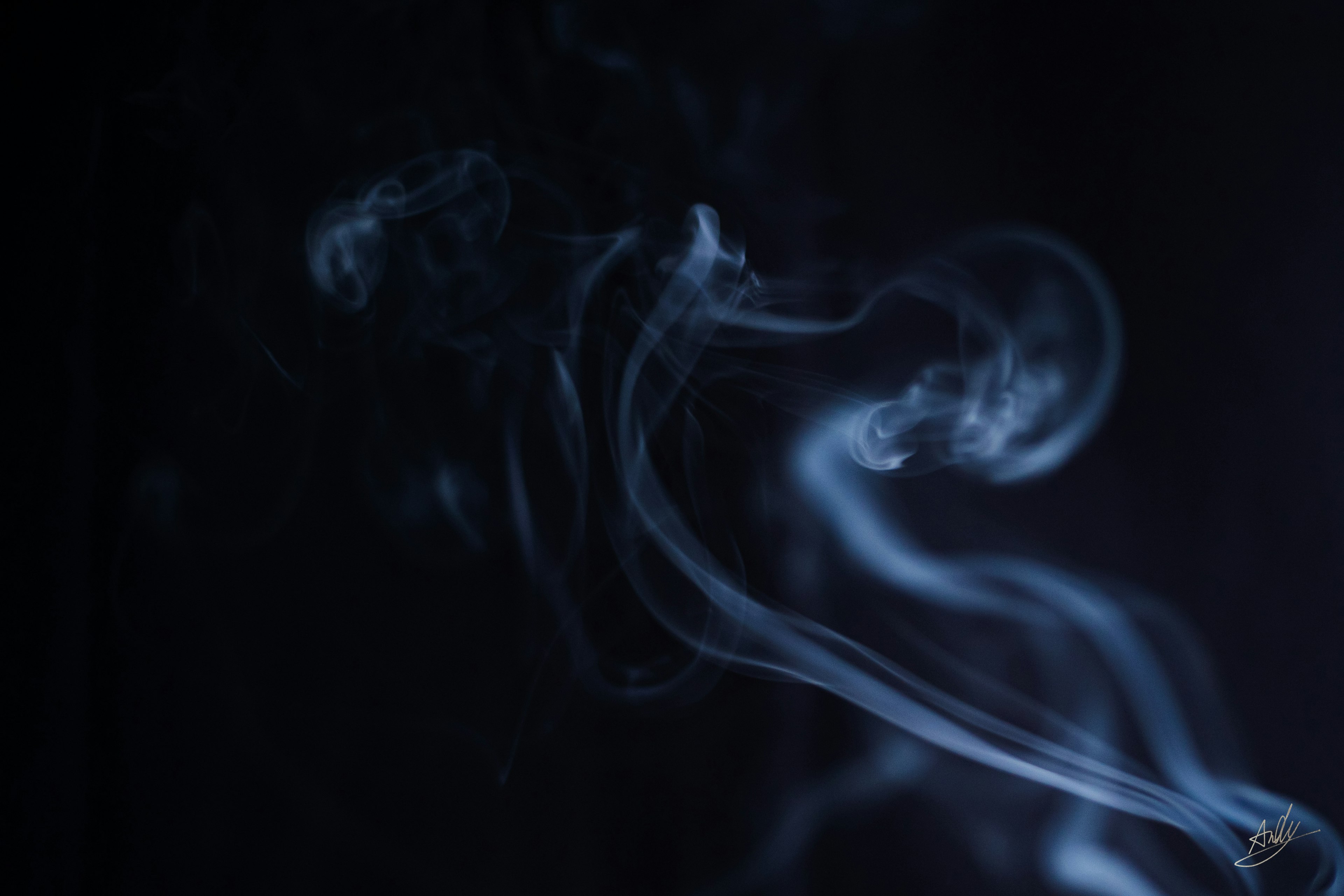 Flow of blue smoke against a dark background