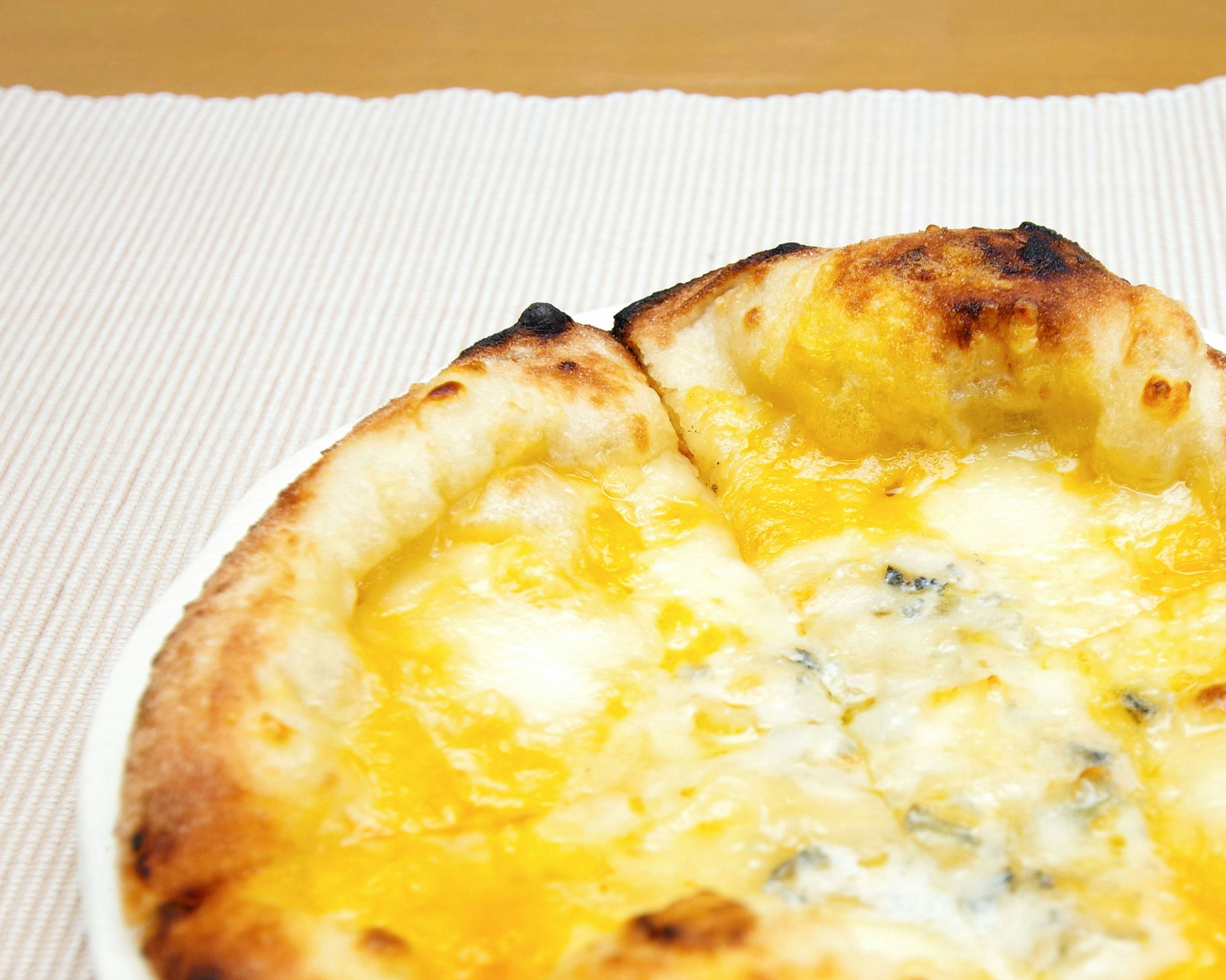 Primer plano de una pizza de queso recién horneada con queso derretido y masa crujiente