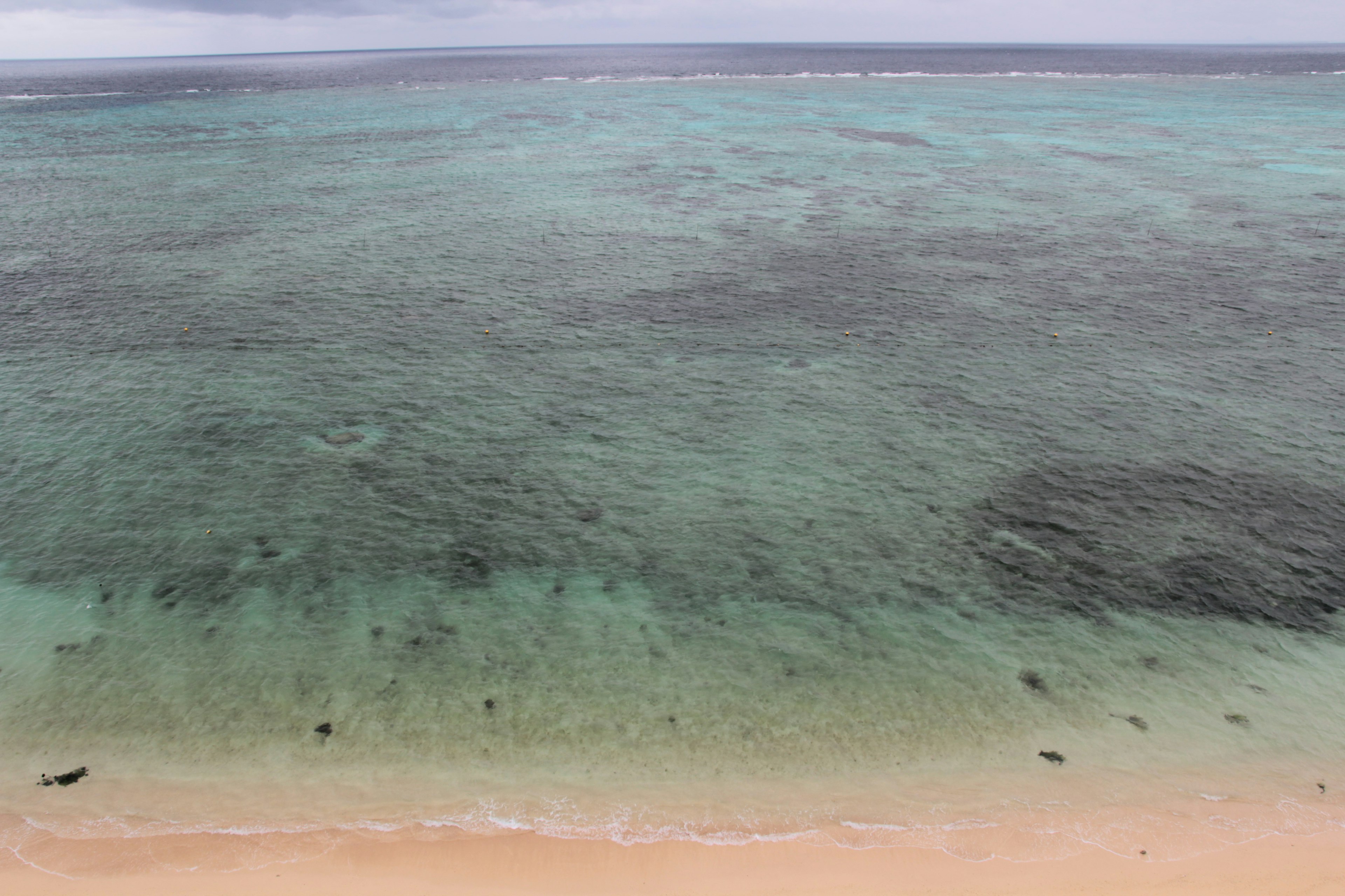 Aerial view of turquoise water meeting sandy beach