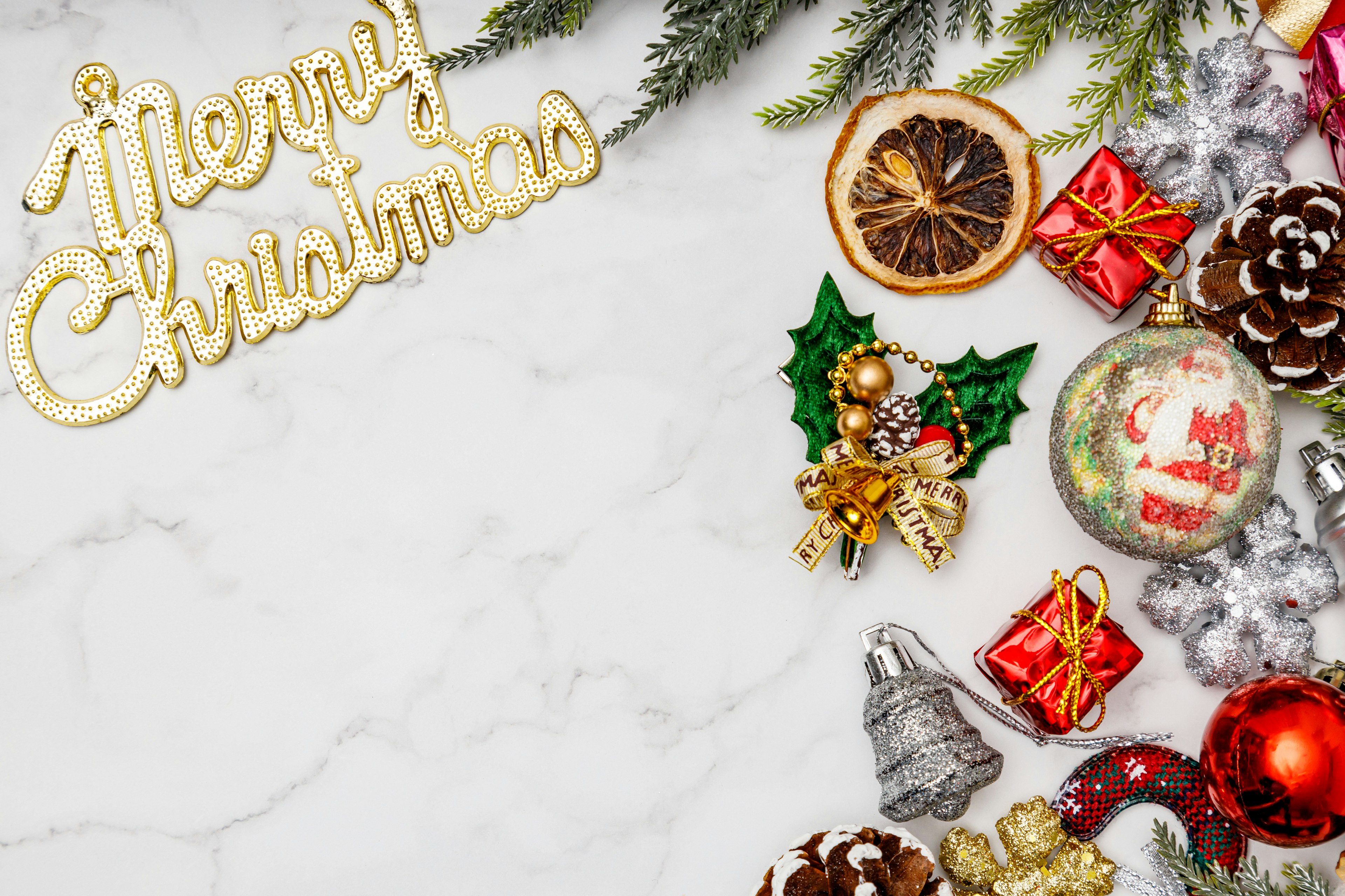 Image featuring Christmas decorations and gifts on a white marble background with the text Merry Christmas