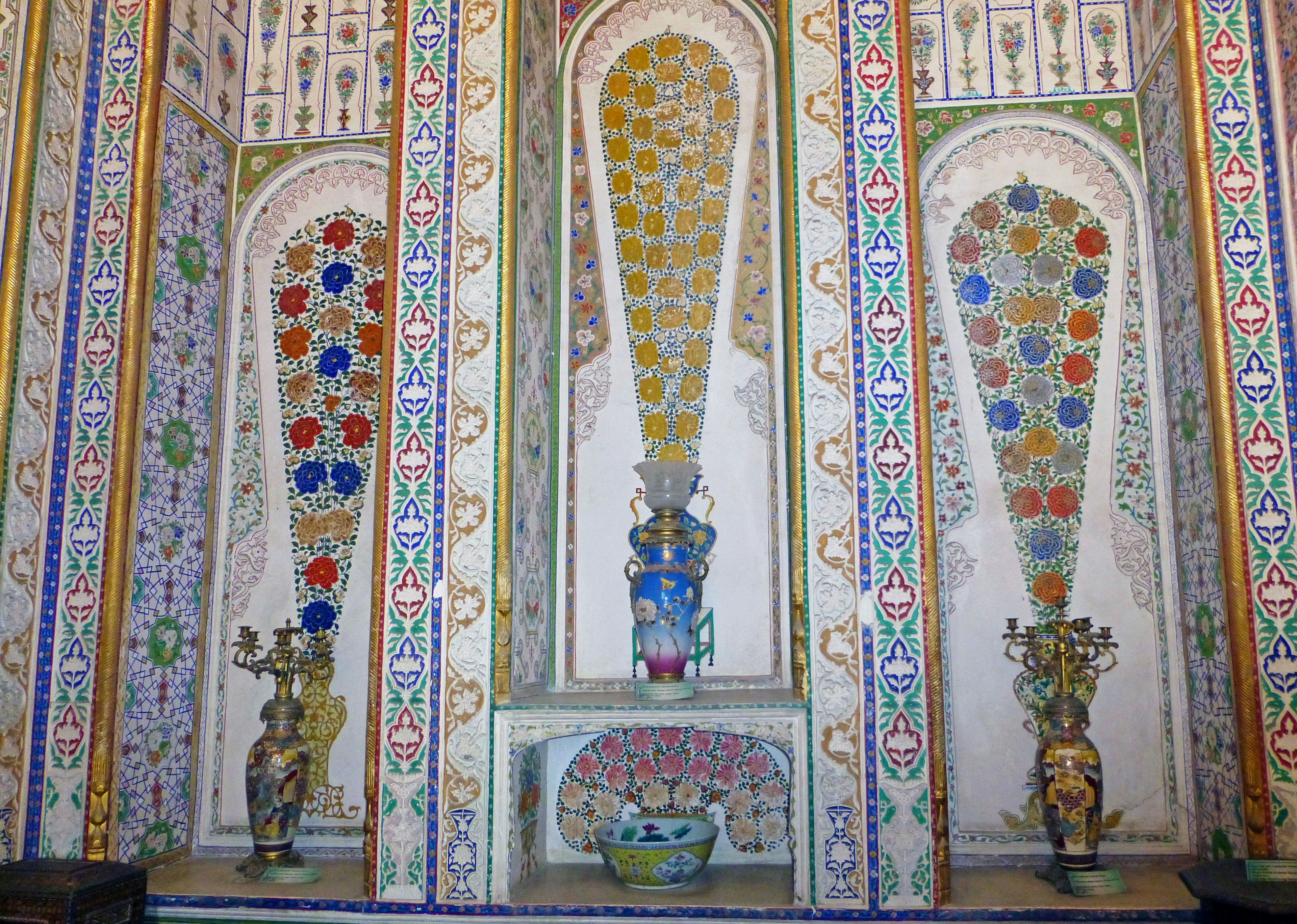 Interior featuring arched niches with floral motifs and vibrant colors on the walls