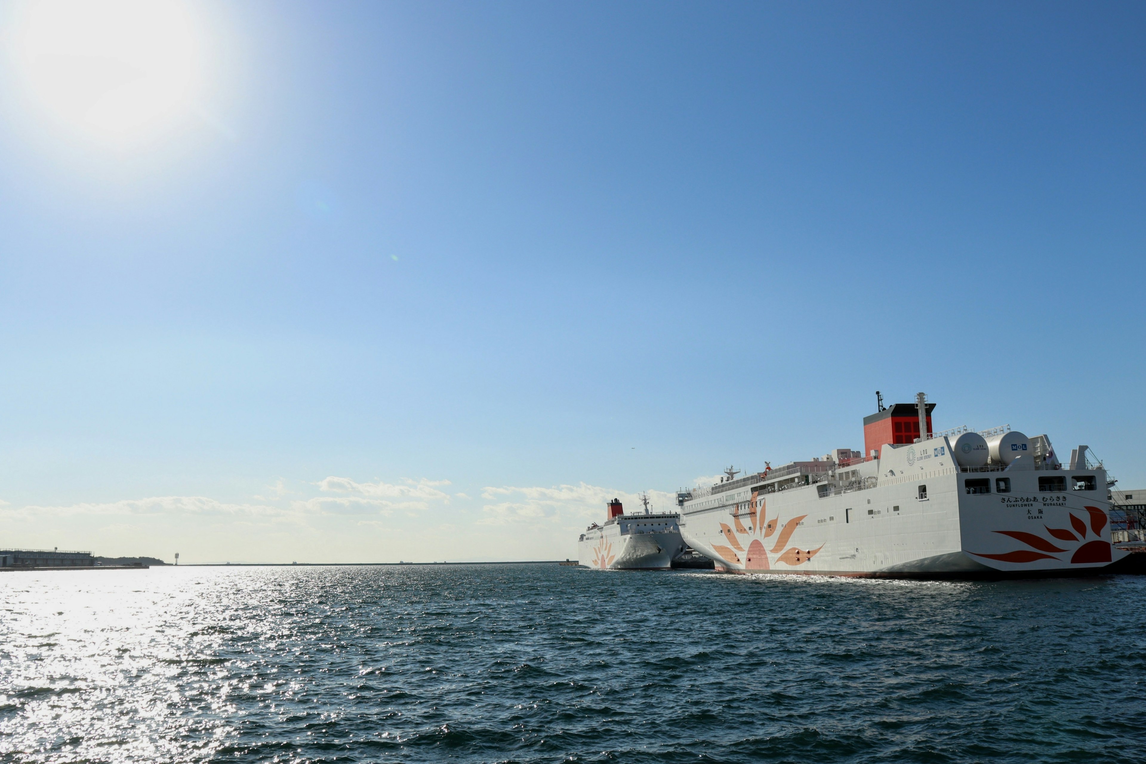 Large ferry docked under a clear blue sky with the sun shining