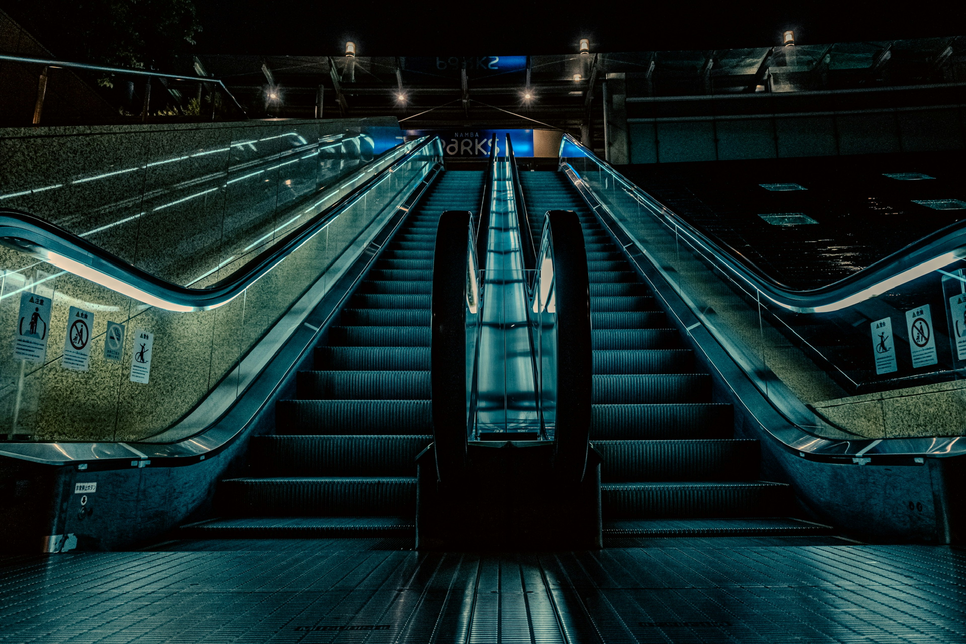 Image of escalators and stairs in a dimly lit station