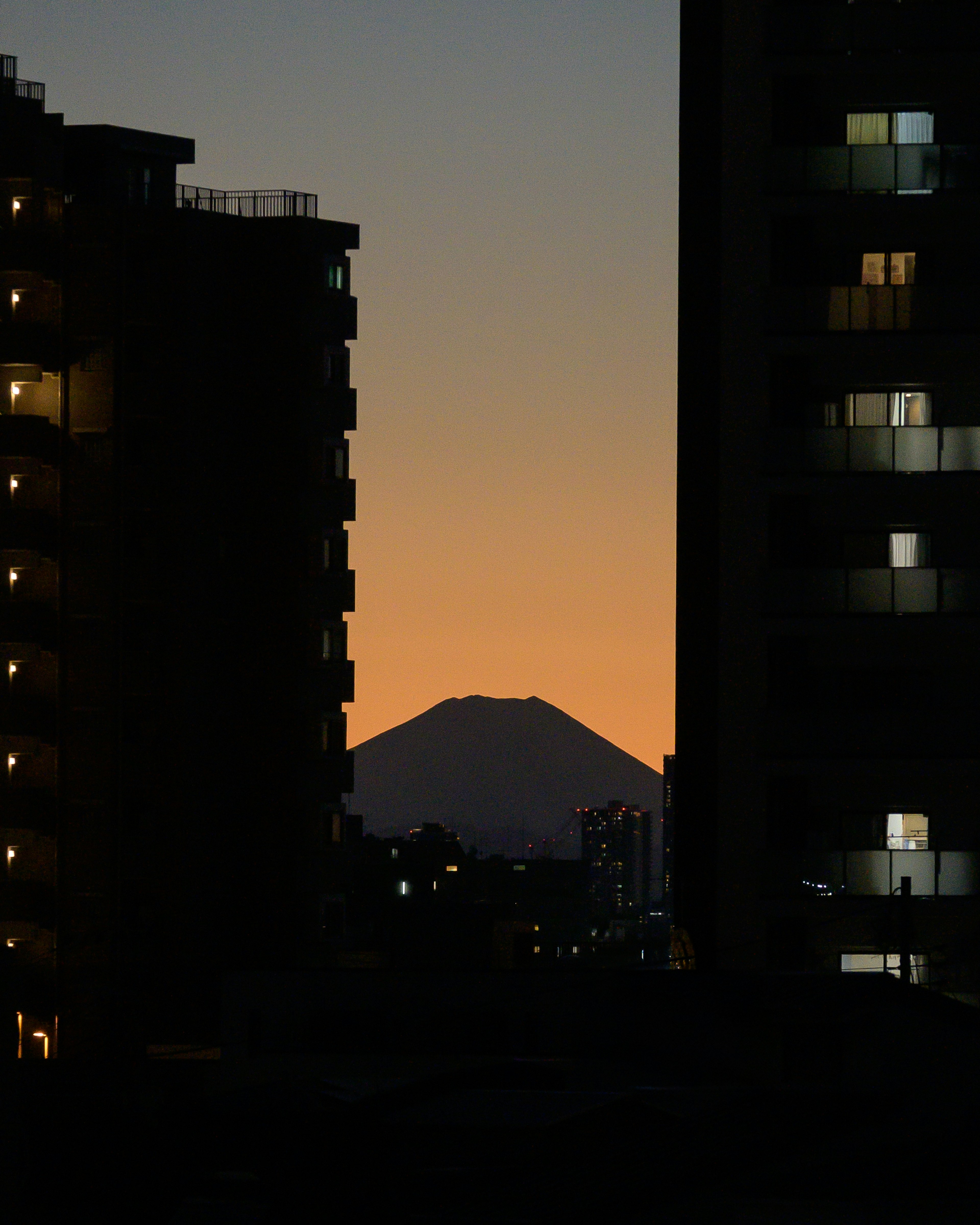 夕陽下建築間的富士山景觀