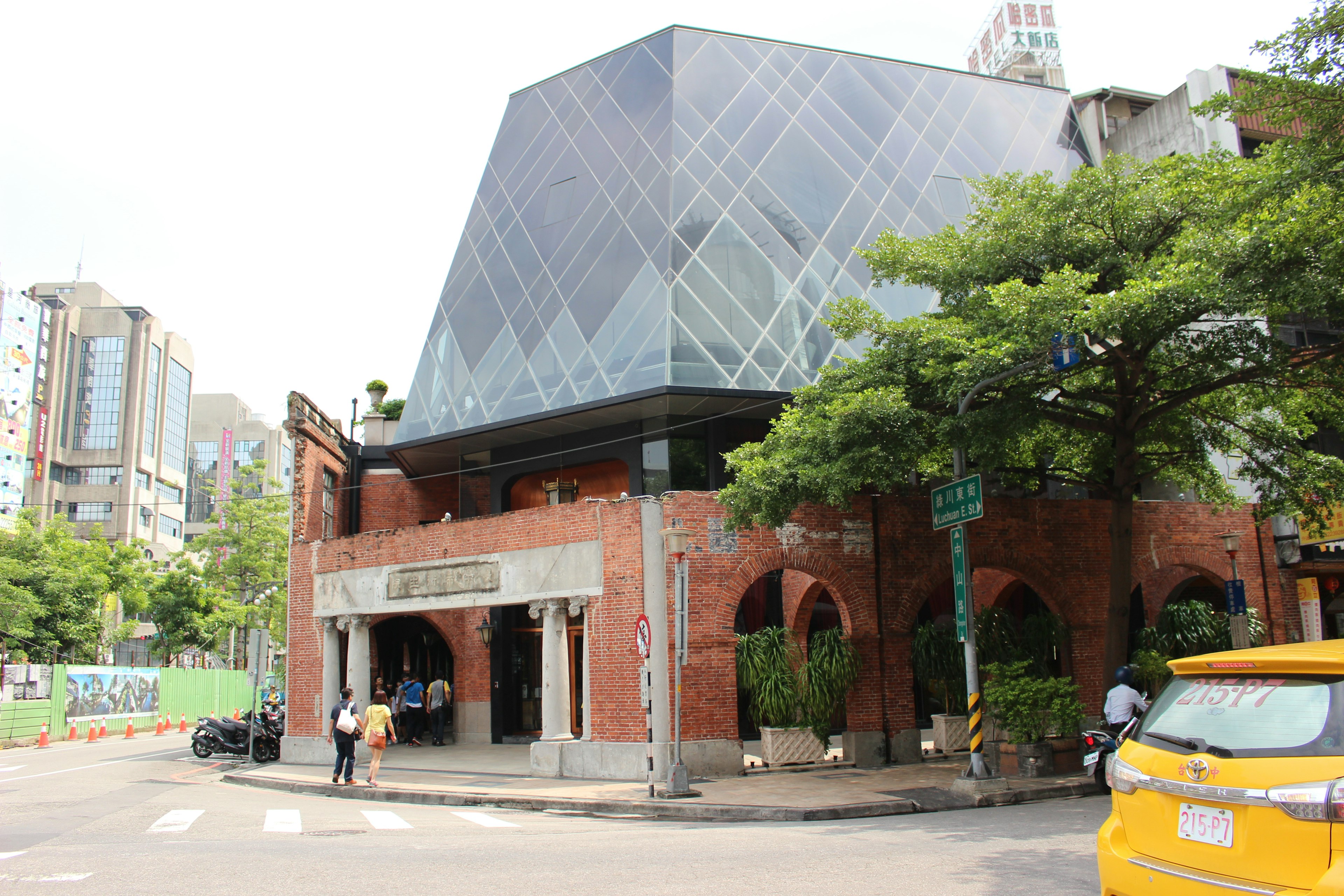 Modern glass-roofed brick building at a street corner