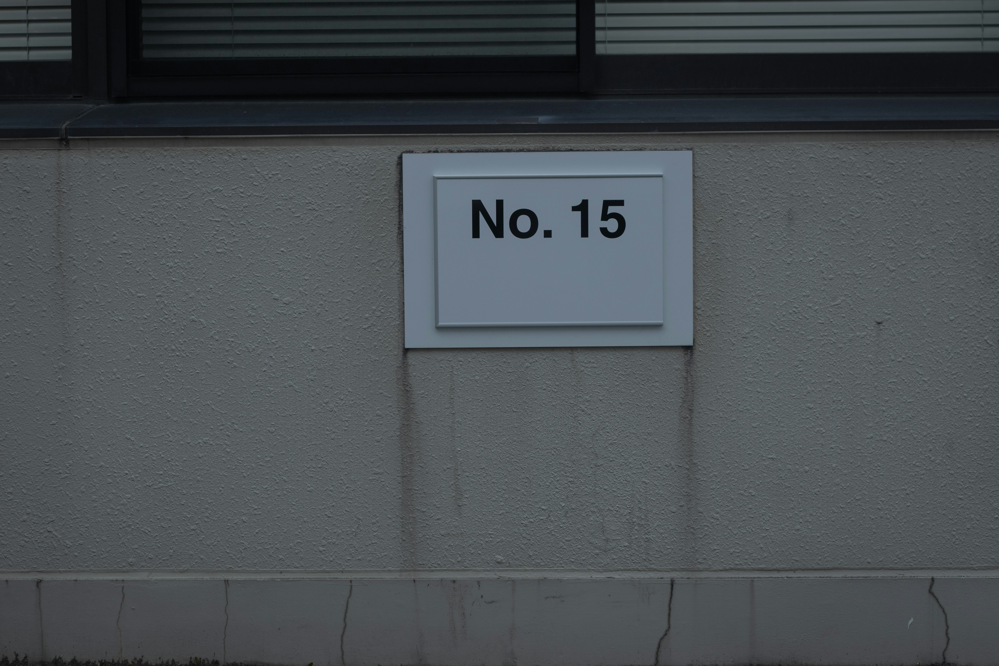 A wall-mounted plate displaying the number 15