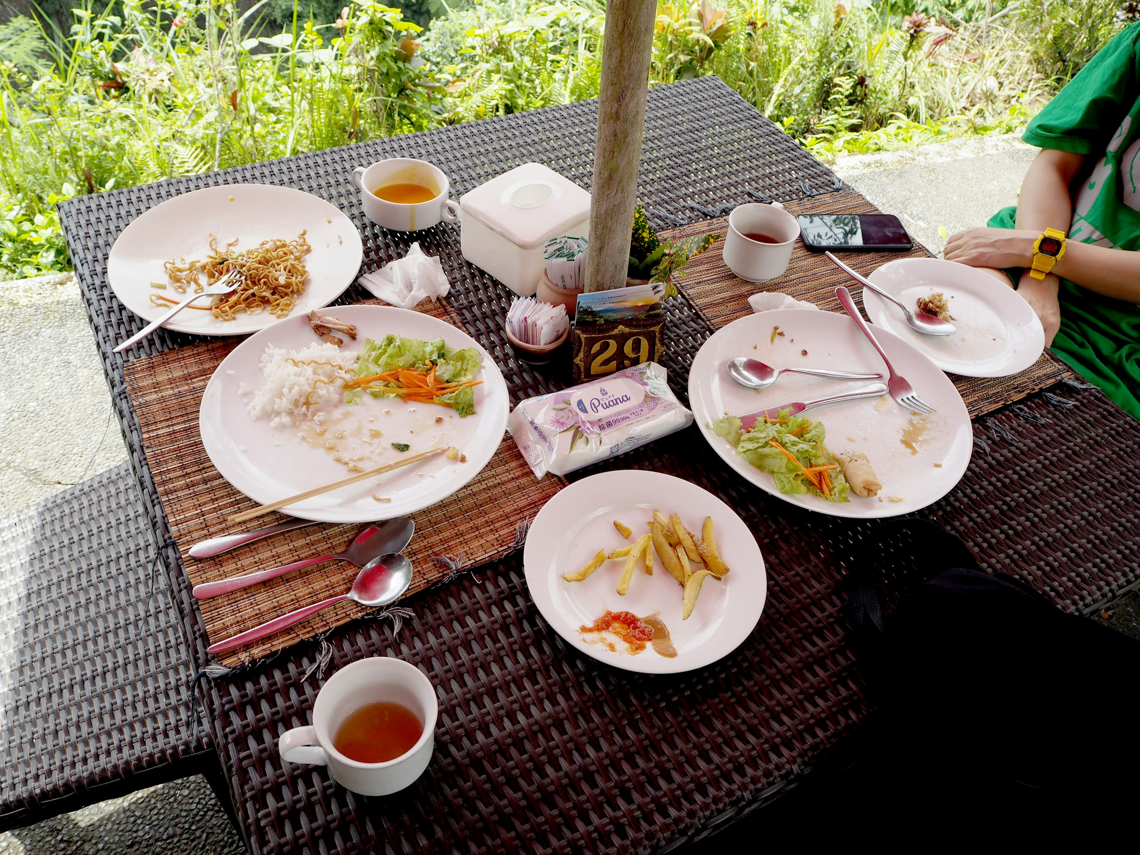 Table with leftover food on white plates and tea