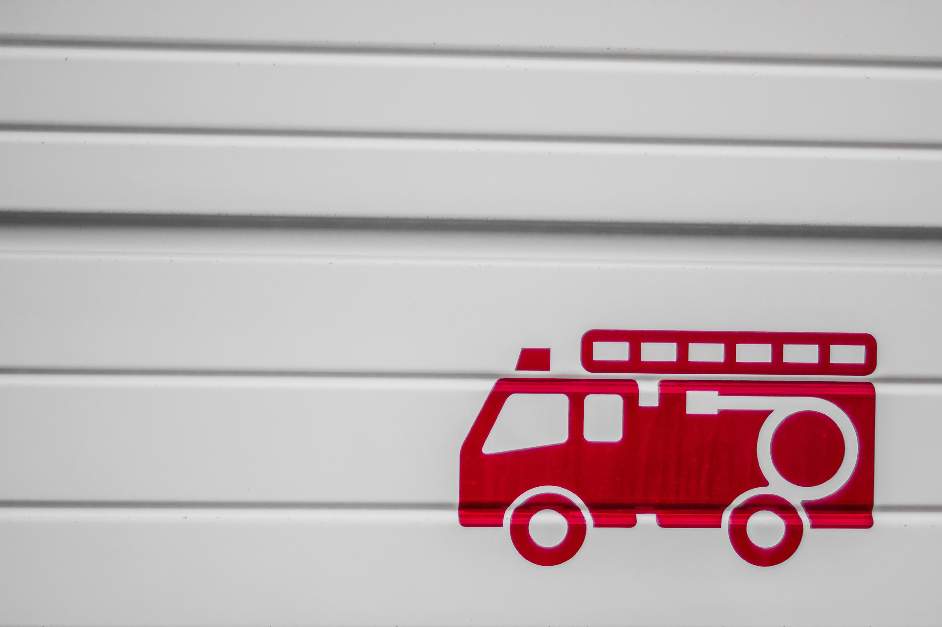 A red fire truck icon on a white wall