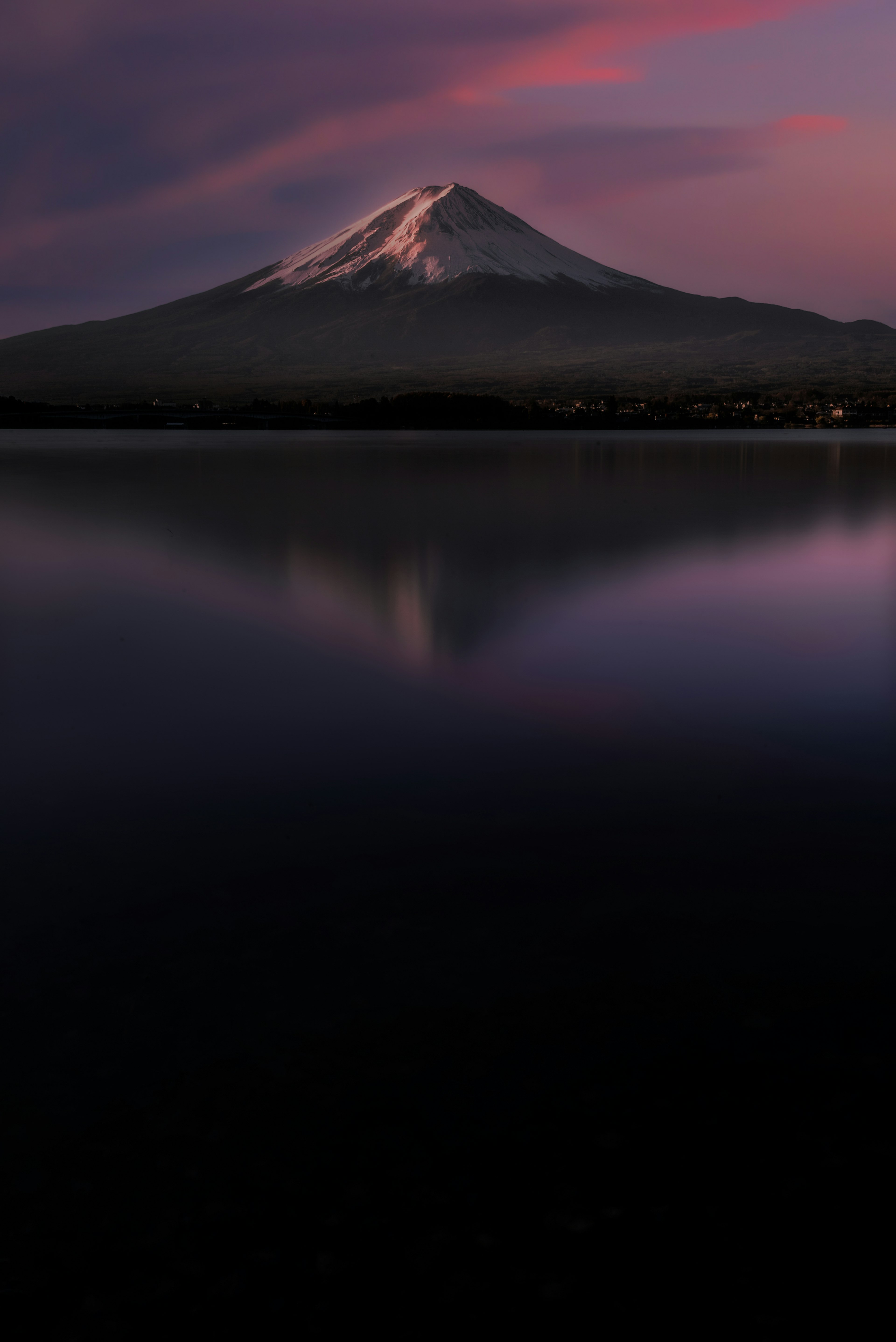 Mount Fuji illuminated by sunset reflecting in the lake