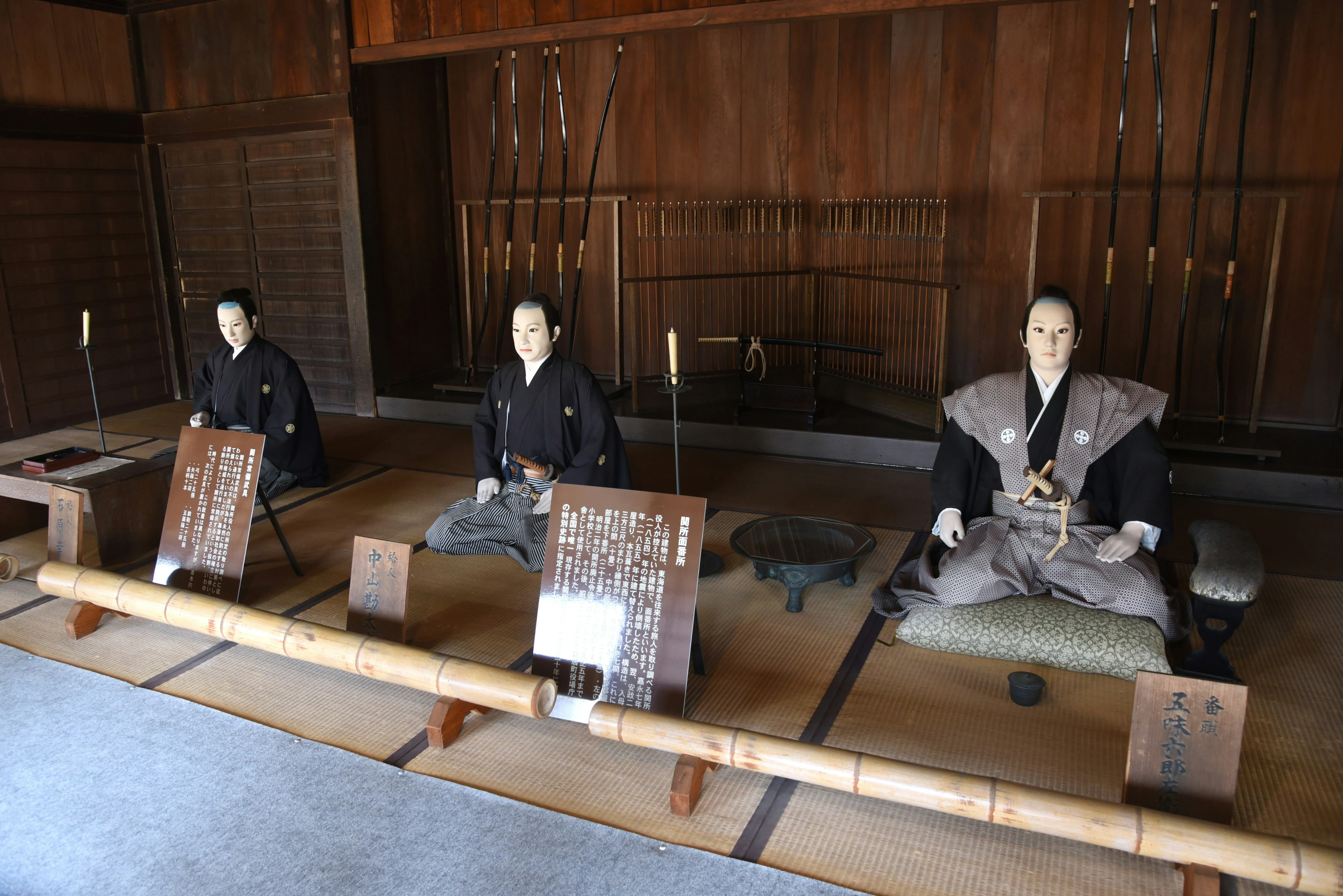 Tre figure di samurai sedute in una stanza giapponese tradizionale